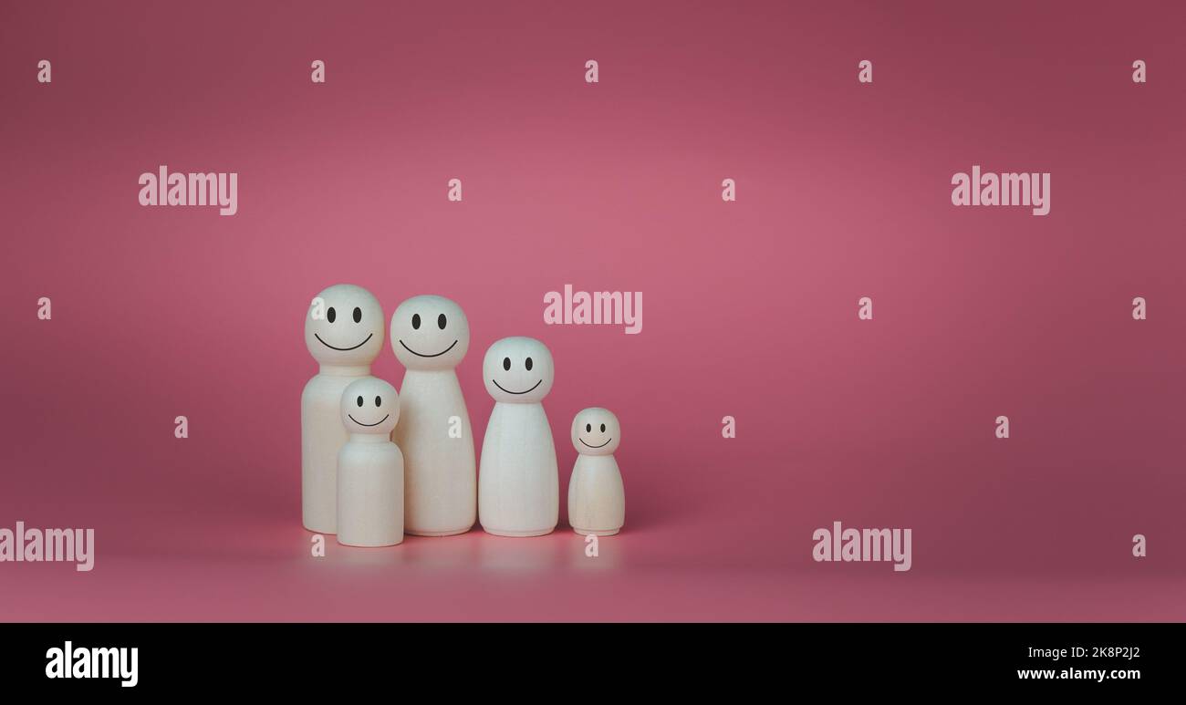 Happy house concept. Wooden dolls stand lined up against a pink