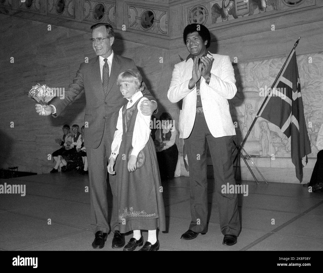 Oslo 19830629. USA Vice President George Bush on an official visit to Norway. Cultural event in Oslo City Hall. Bush receives flowers from girl in bunad. Singer Bobby Lee to H. Photo: Erik Thorberg / NTB Stock Photo