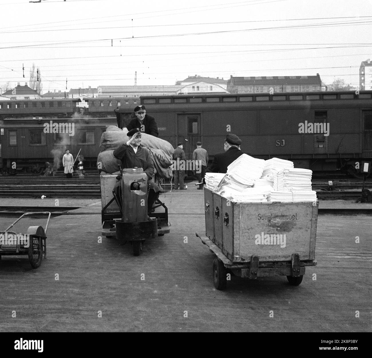 Oslo 19600106: In 1960, NSB had 3212 beds in their sleeping wagons, and they became increasingly popular. Every day, an army of cleaners moved into NSB's area in Lodalen, to wash, clear and change bedding. Dirty clothes out, clean cloth in. The cleaning staff greets, while driving the small motorized wagons with bed change to and from NSB's laundry in Lodalen, where in 1959 1.5 million kilos of cloth was washed only from the sleepers. Around Christmas there are often 3000 sheets per day! Photo: Ivar Aaserud / Current / NTB Stock Photo