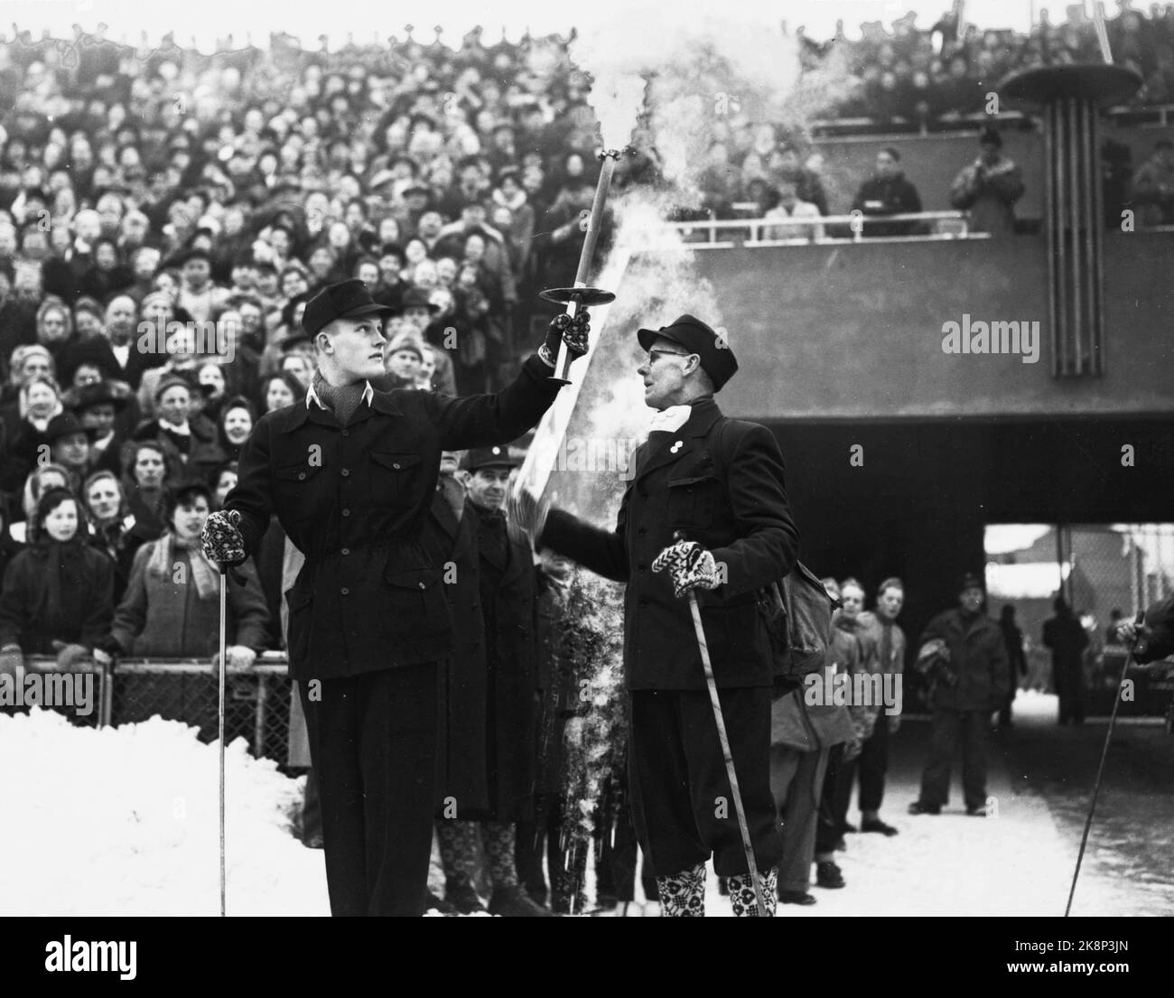 Oslo 19520215 The Olympic Winter Games in Oslo: The old disc veteran Lauritz Bergendahl delivers the Olympia torch to Eigil Nansen at the opening ceremony at Bislett Stadion Olympics 1952. Photo: NTB / NTB Stock Photo