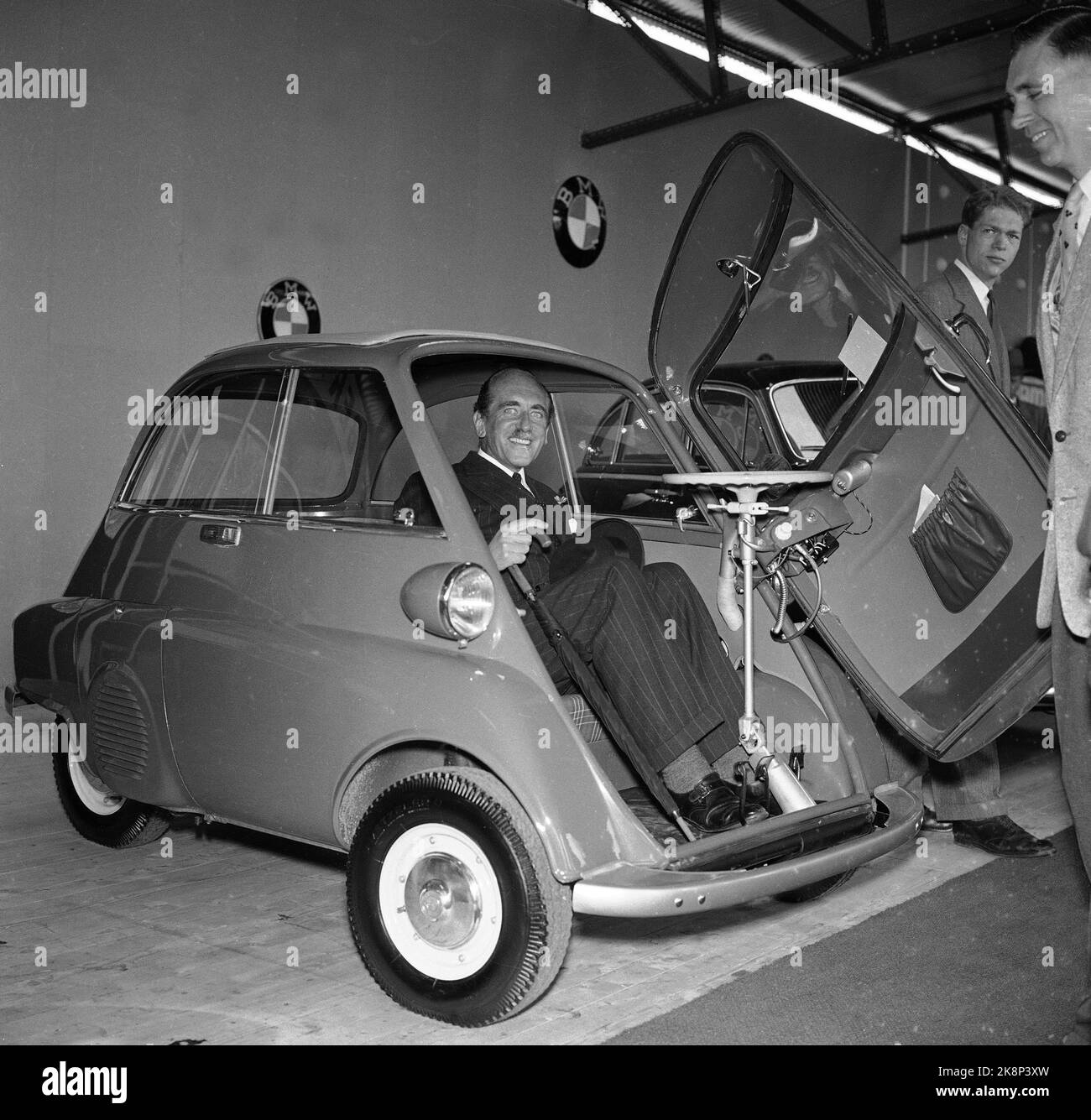 Oslo 19570503 Car show at Filipstad. Here is a curious BMW, a BMW Isetta. Tiny, with door front and two tight -fitting wheels behind. It is obviously marketed as a perfect city car, as it is an elegant businessman with a striped suit and umbrella showing the car. Photo: NTB / NTB Stock Photo