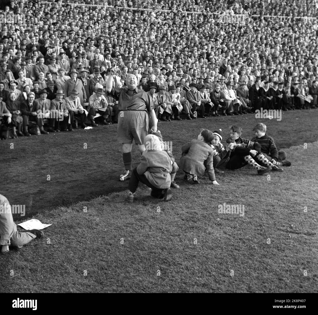 Oslo, 19561021. The cup final at Ullevaal Stadium. Larvik Turn - Skeid 1-2. Skeid supporter and revue artist Einar Rose waves a pennant. Young boys along the sidelines look strange at him. Photo: Current / NTB Stock Photo
