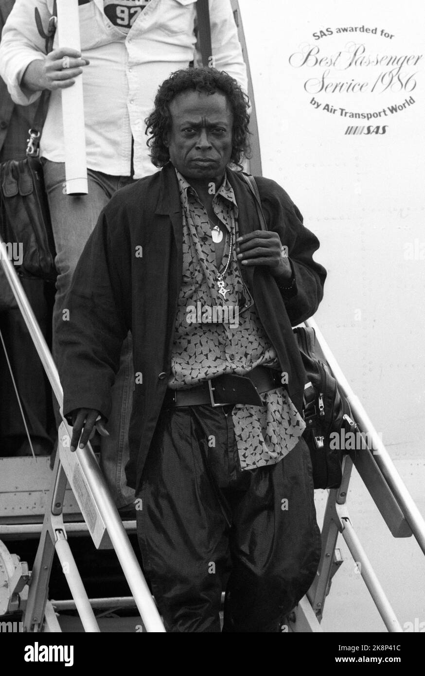 Oslo 19870707. Jazz musician Miles Davis on the way down the flight staircase at Fornebu. He comes to Oslo to have a concert at Sardines. Photo Eystein Hanssen / NTB / NTB Stock Photo