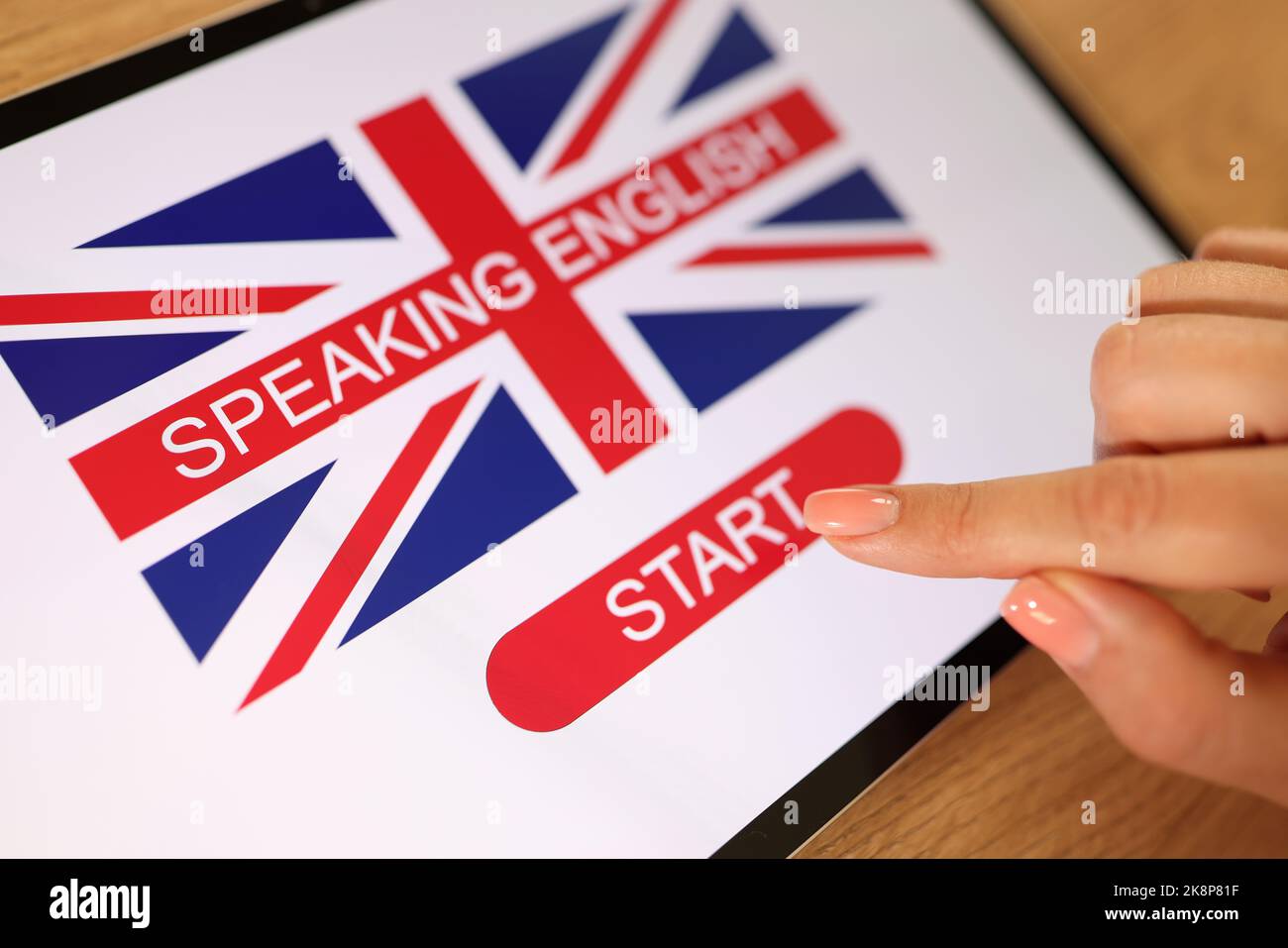 Female hands press button start in application for learning languages Stock Photo