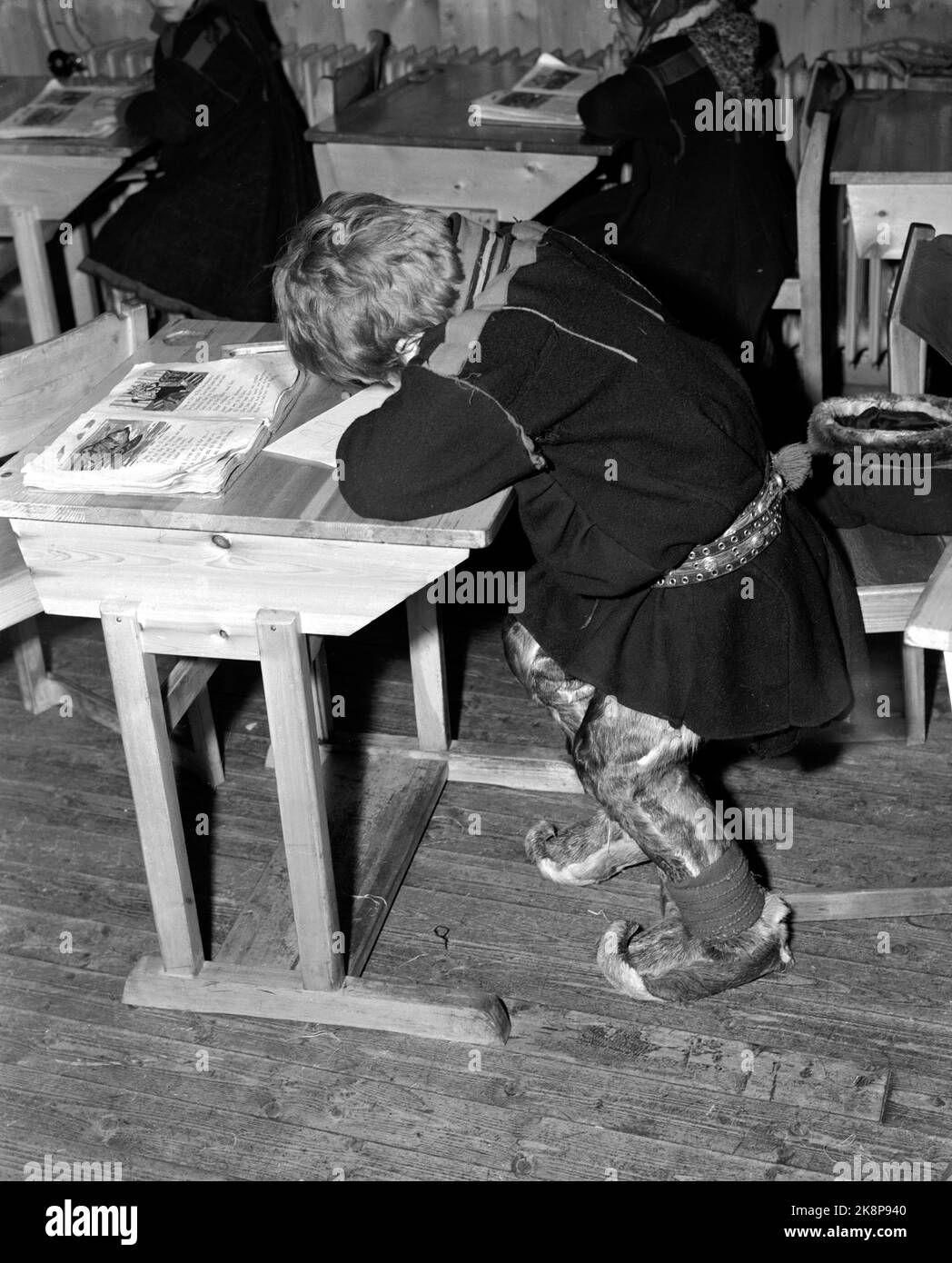 Karasjok, Finnmark, January 1950. From the boarding school for moving-side children. The Sami children live at boarding school. Here interiors from a classroom. For the Sami children, sitting on a chair and having your legs on the floor is a big transition. This boy struggles to adapt to life at the school desk. Photo: SV. A. Børretzen / Current / NTB Stock Photo