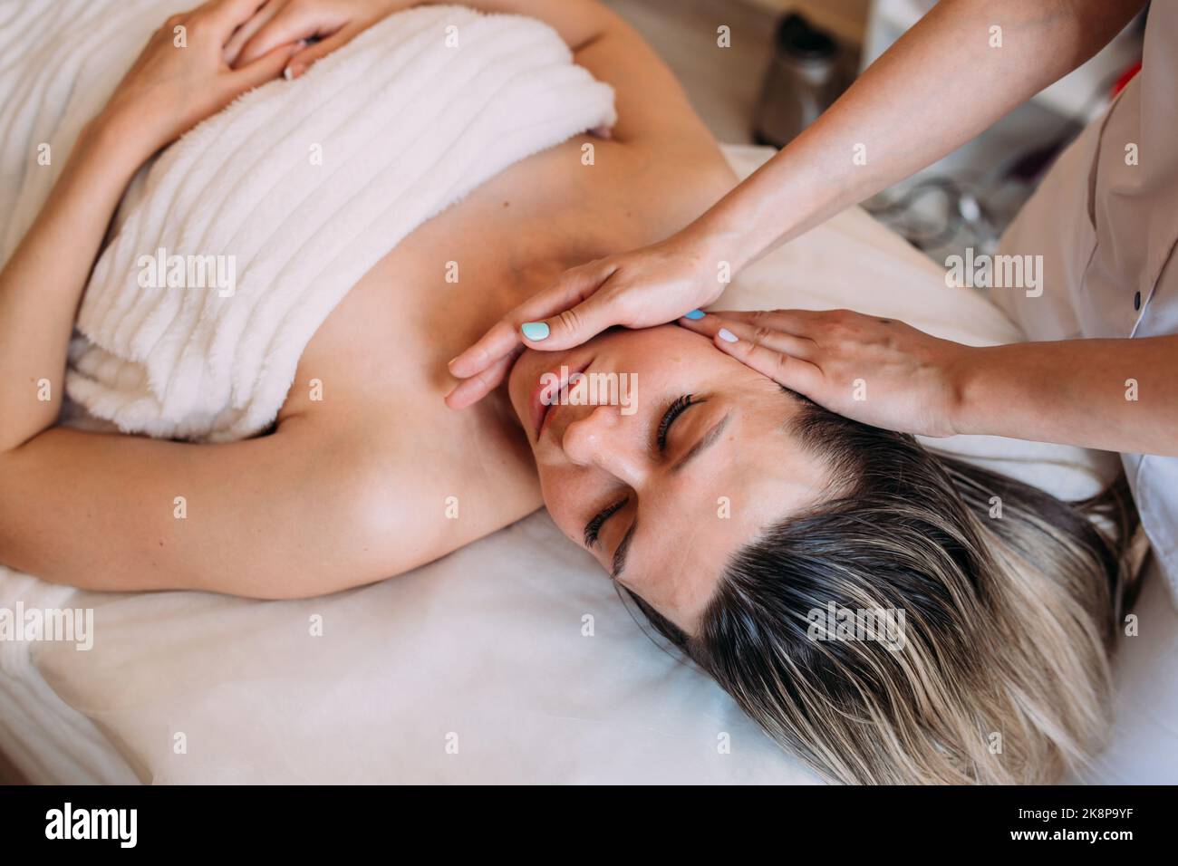 Cosmetologist does facial massage for woman. Beauty skin care Stock Photo