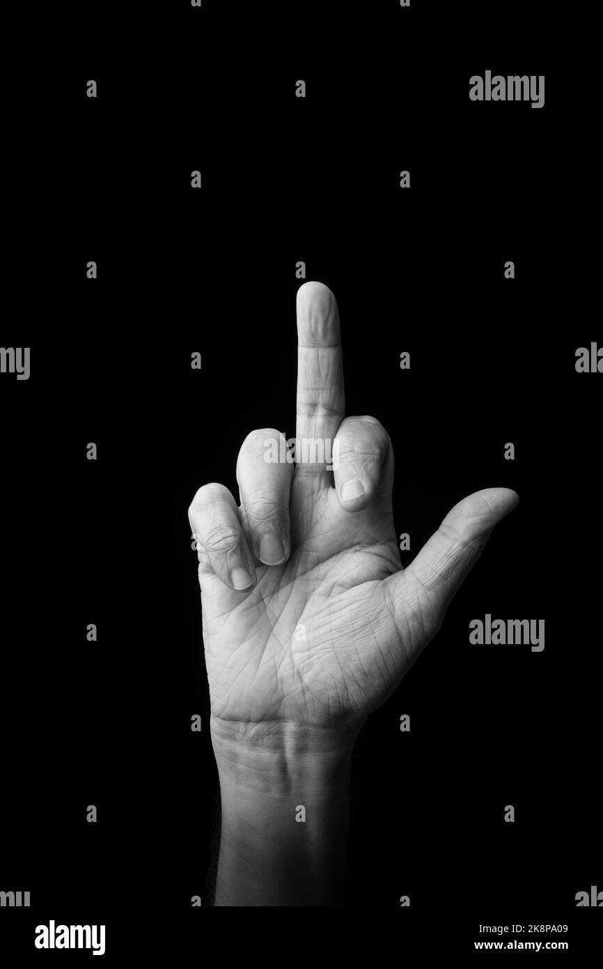 Dramatic black and white image of a male hand fingerspelling the Japanese sign language letter 'SE' or 'せ', against a dark background with copy space Stock Photo
