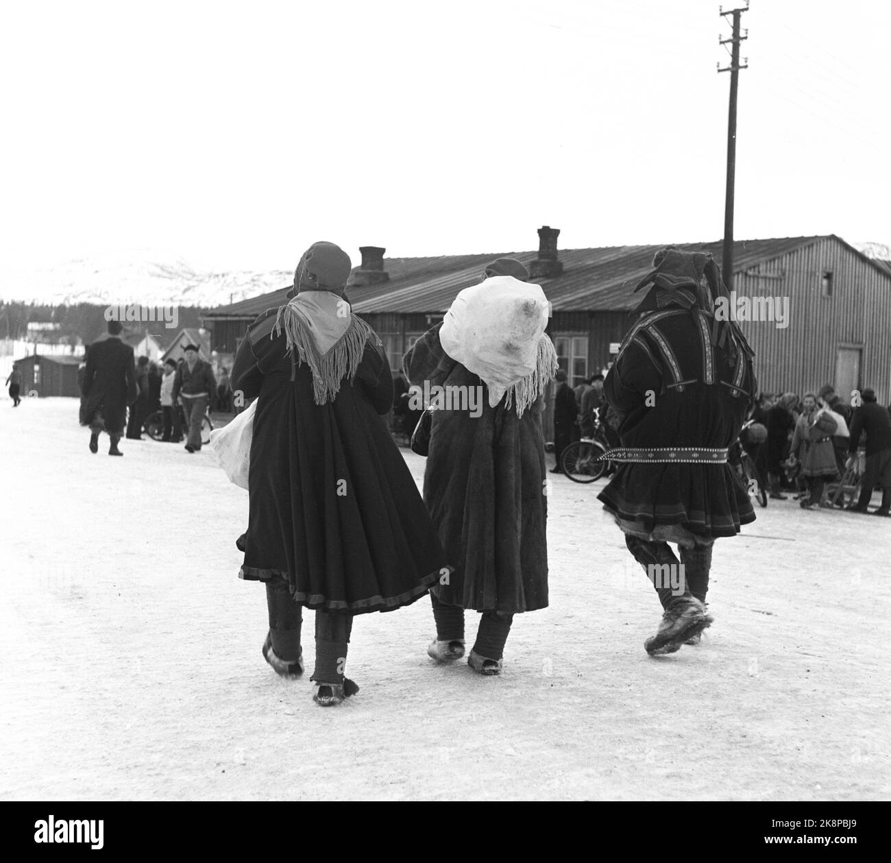 Alta, Bossekop 19520419. Bossekop- The market, the large famous Sami market that is gathered every year at the Samvirkelaget in Alta. Here, there are many from the ridges nearby to sell household goods, reindeer meat and leather. The trade goes lively. The goods are transported in bags by truck from Gargia Fjellstue, which is the gathering place for the Sami after they have come down from Vidda. About. 40-50,000 kg. Meat is delivered to the market. Here we see Sami On the way to the market with sack on the back. Photo: Sverre A. Børretzen / Current / NTB Stock Photo