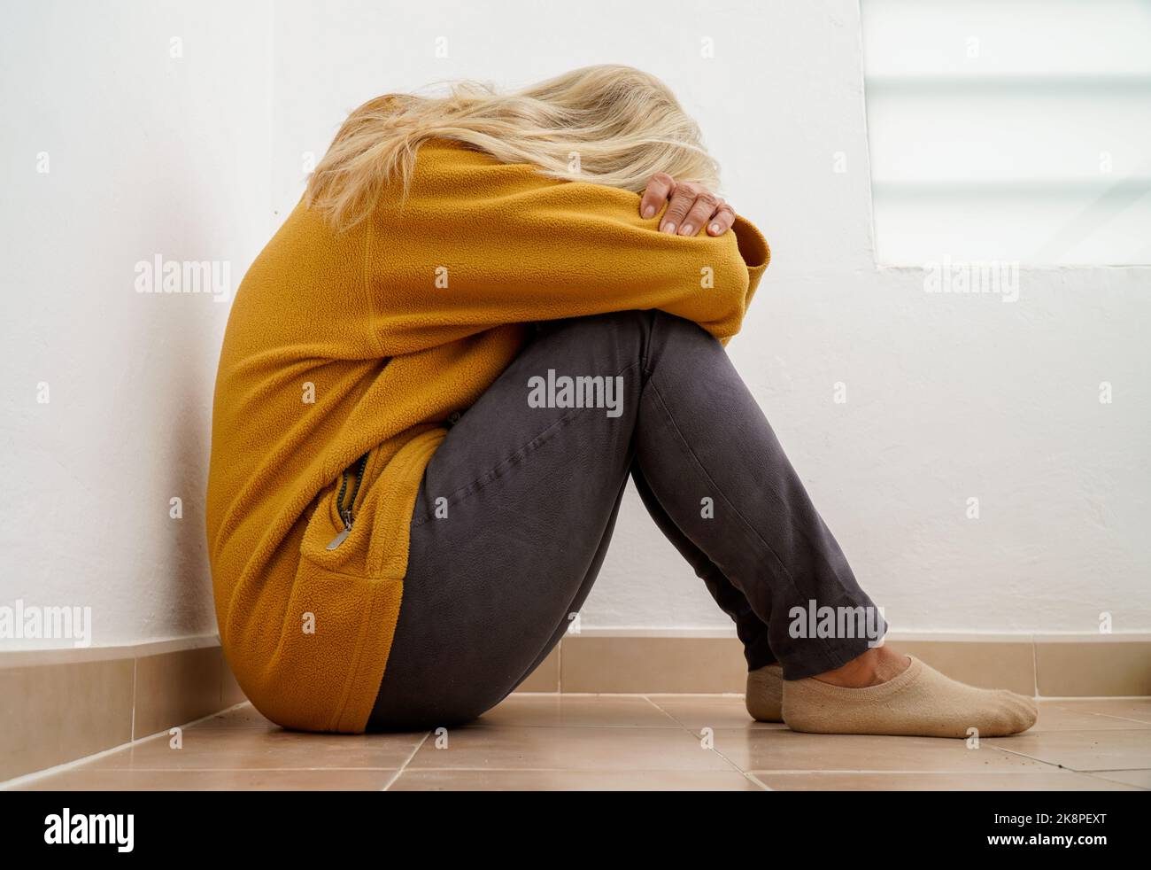 Sad and depressed woman sitting with her head down. elderly lady with