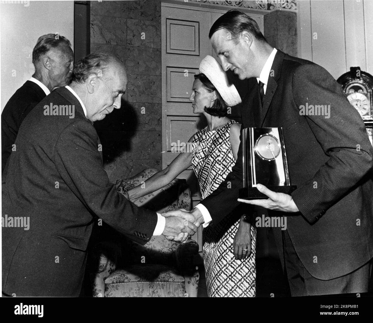 Oslo 1968-08-29: Royal Norwegian wedding. Crown Prince Harald marries Sonja Haraldsen. The couple received a lot of gifts. Here they receive the gift from Oslo city by Mayor Brynjulf Bull, a clock. Sonja in hat and short dress, Harald in suit. Ntb archive / ntb Stock Photo