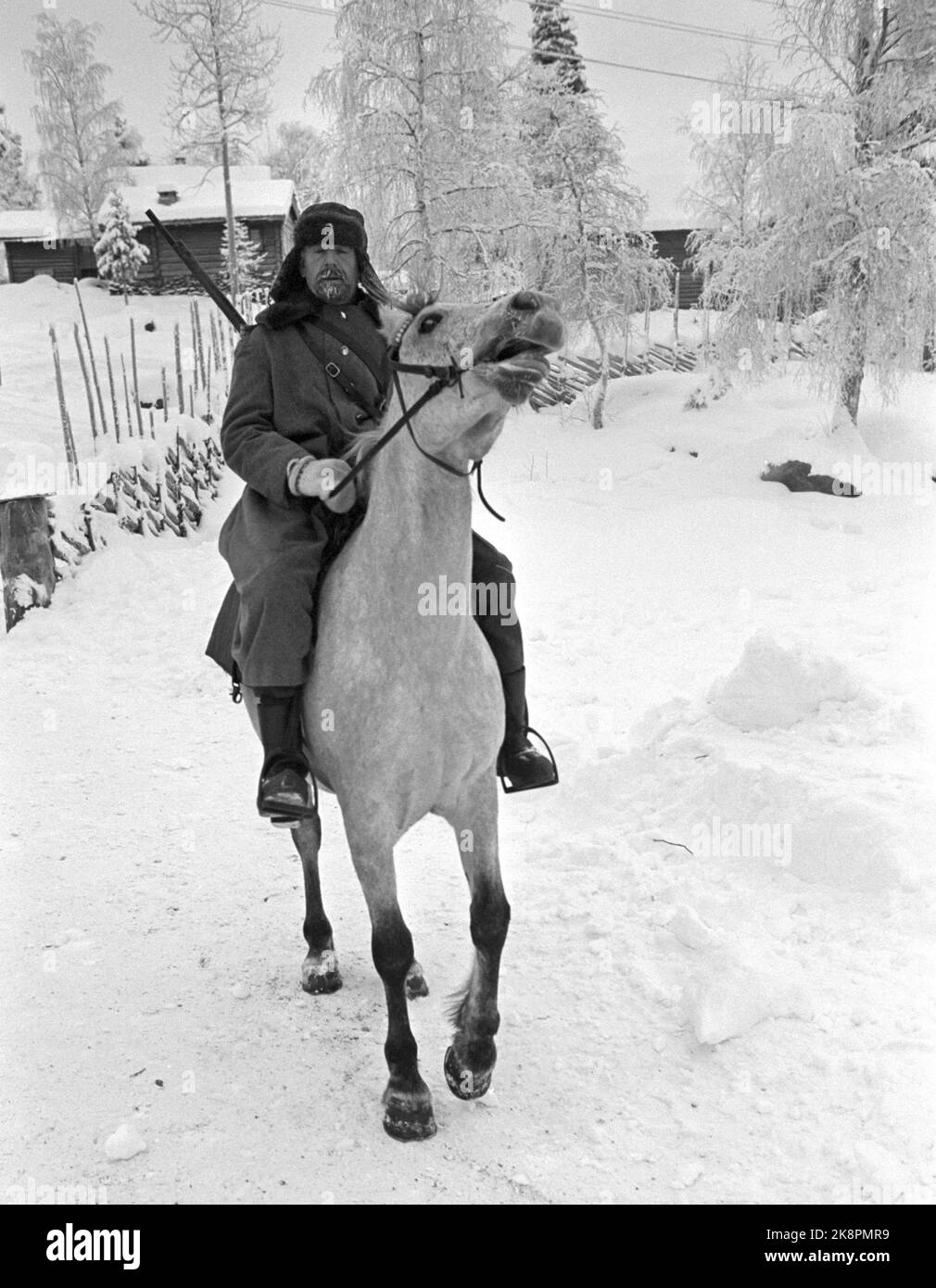 Fagernes 19680120 'Contra revolution on Fagernes.' The German television company Zweite Deutsche Fernsehen occupies important scenes at Fagernes for the large semi-documentary film about the counter-revolution in Russia in 1920-1921. A Siberian village is built on Valdres Folk Museum's land, and this village is set in fire and the inhabitants are chased out. Hans Velund in Oslo had to provide ten horses and just as many riders. There are no horses in Valdres, namely. He himself played Partisan, and the riders did a very good job. Photo; Aage Storløkken / Current / NTB Stock Photo