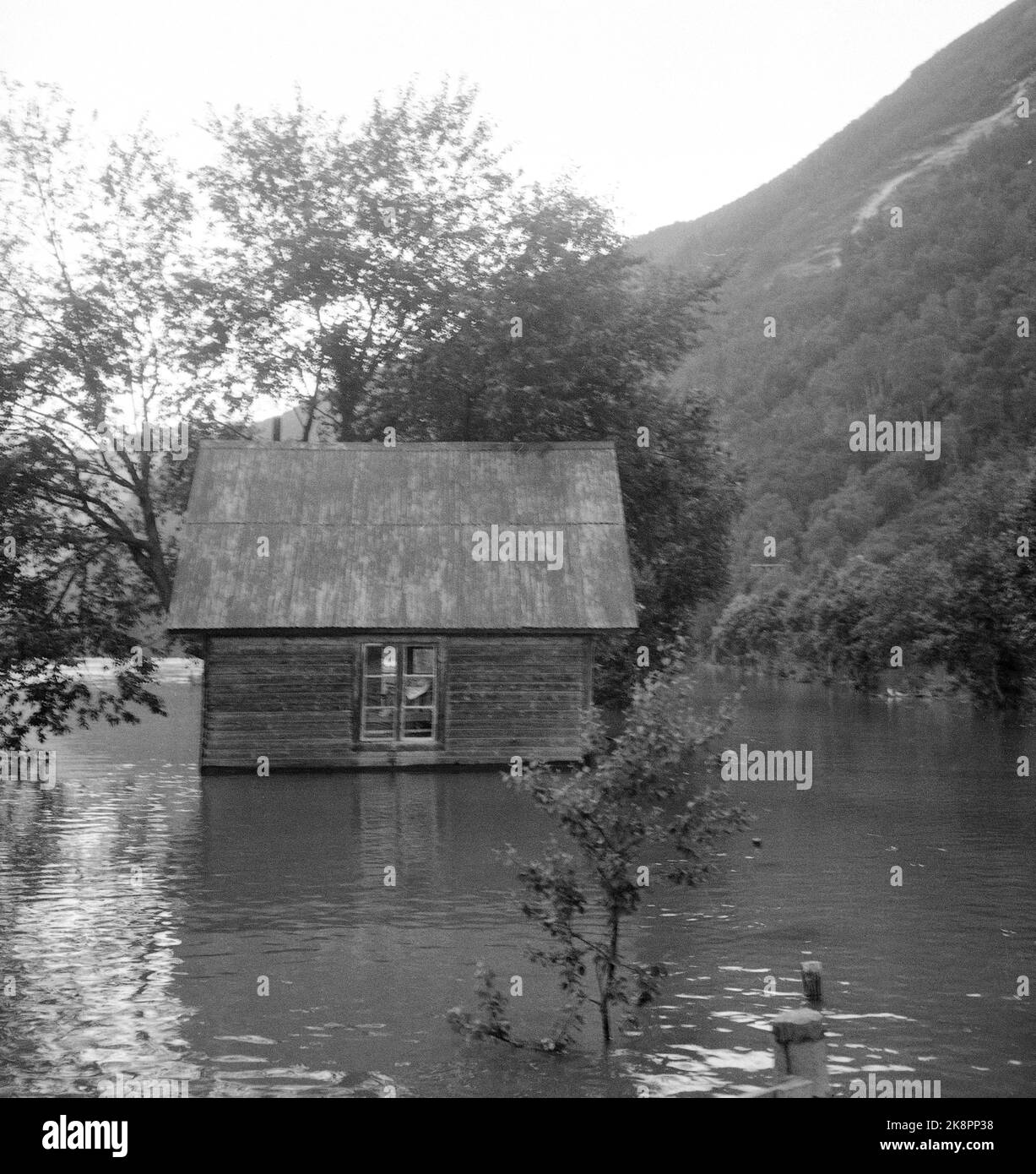 Gudbrandsdal / Møre og Romsdal19580703: Record heat and fast snowmelt in late June and early July led to floods in Romsdal and Gudbrandsdal. Here is a small, old log house that is completely surrounded by water on all sides. Photo: NTB / NTB Stock Photo