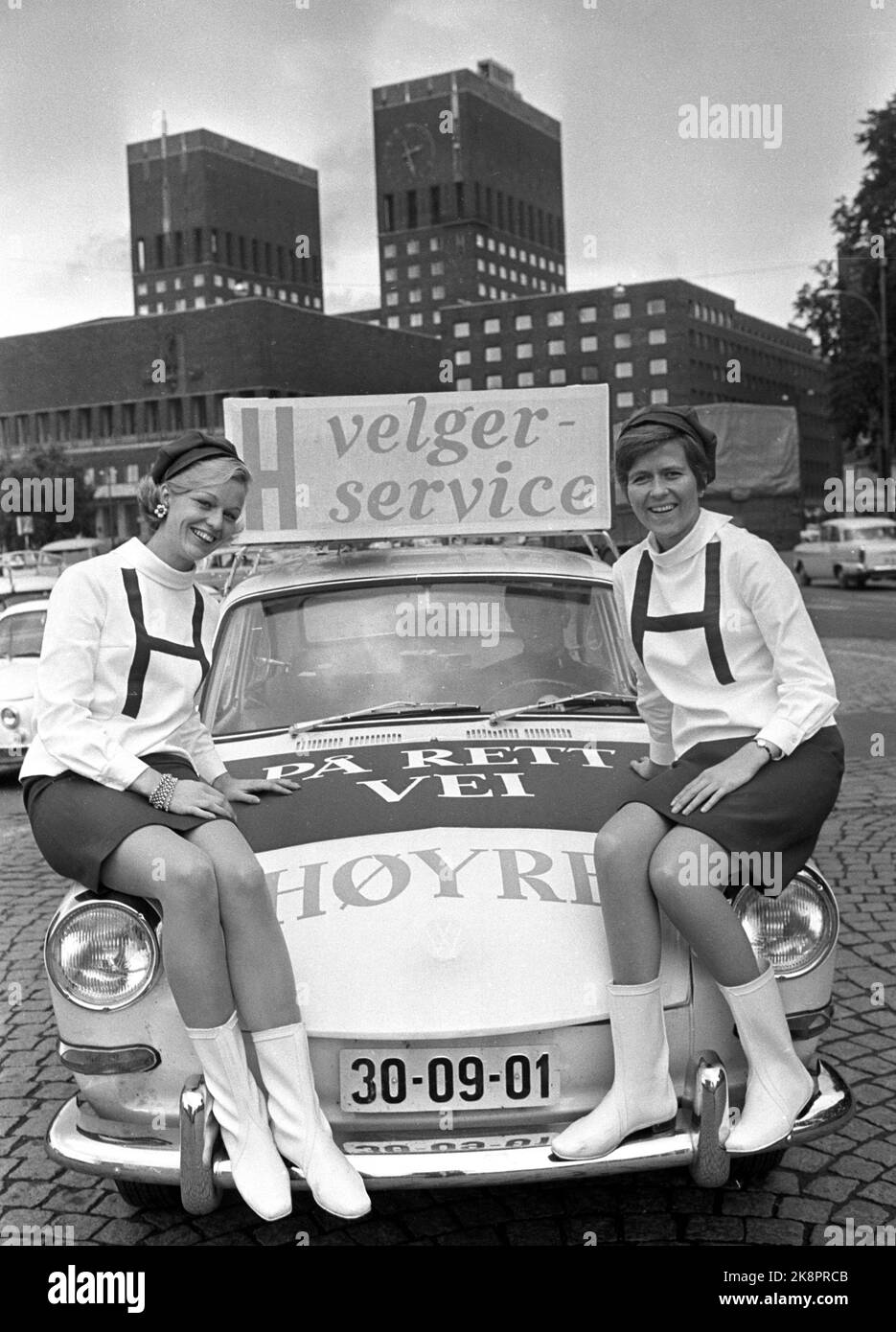 Oslo 19670924 Municipal elections 1967. The party Right runs election campaign, among other things. From cars labeled 'right voter service'. Here two of Høyre's choice hostesses, fashionable dressed in mini skirts and white boots, sitting on one of Høyre's election cars, photographed in front of the Oslo City Hall. Photo: Hordnes / NTB / NTB Stock Photo