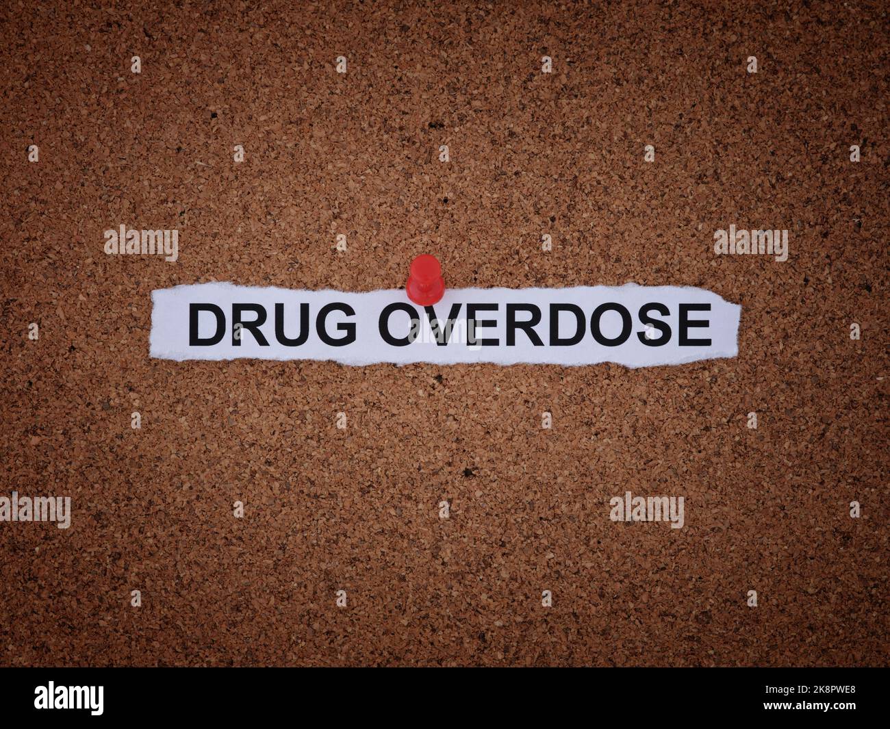 A paper note with the words Drug Overdose on it pinned to a cork board. Close up. Stock Photo