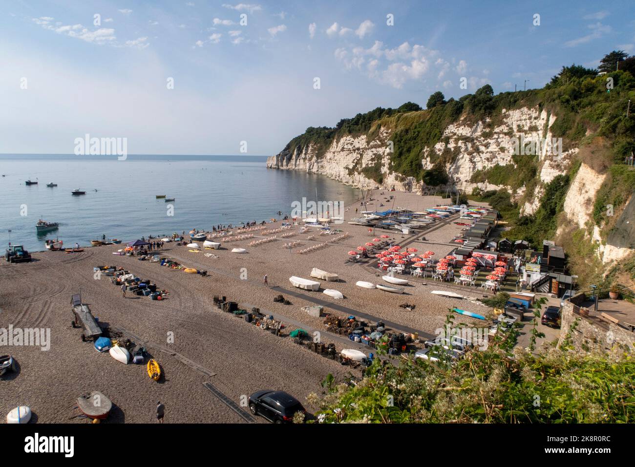 View across the beach and bay in Beer, Devon, with beach cafe on the shingle beach at Beer, a popular fishing village in Devon. Stock Photo