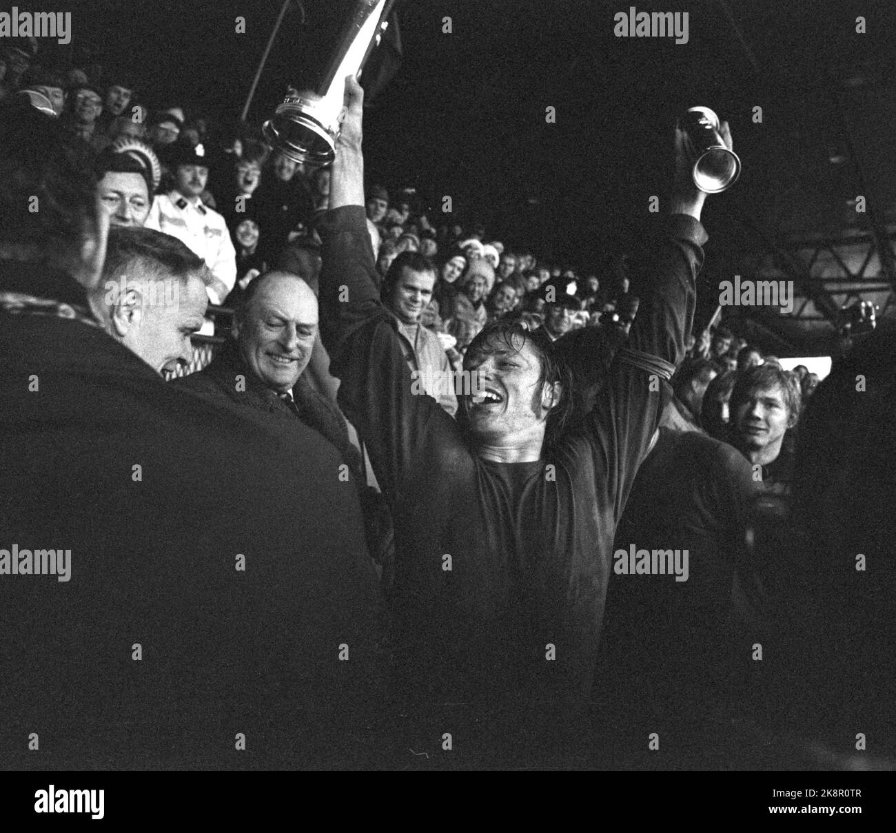 Oslo 19741020. Soccer. Cup final Skeid - Viking 3-1, Ullevaal Stadium. Skeid became Norwegian champions in the rain and sleet. Here, Skeid's team captain Tor Egil Johansen cheers with the royal trophy who he has just received from King Olav. T.v. For the King, Secretary General of the Norwegian Football Association NIC. Johansen. Photo NTB / NTB Stock Photo