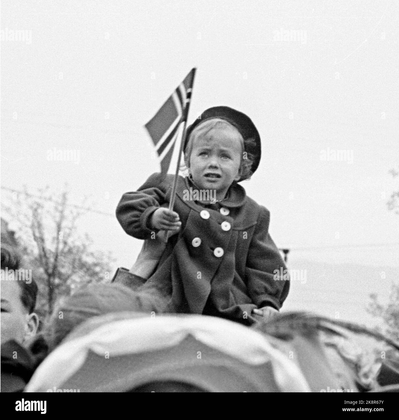 Hamar 19490513. Celebration of Hamar City's anniversary. From the folk train, a small girl with a Norwegian flag sits on his dad's shoulders, and extends over the adults on the train. Photo Sverre A. Børretzen / Current / NTB Stock Photo