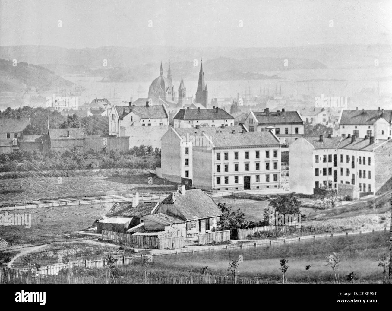 Oslo (undated, c. 1880?). View from St. Hanshaugen. Scattered buildings. The place Mærrahaugen in the foreground. Otherwise mix of urban farms and wooden buildings. The Oslo Fjord in the background. Trinity Church and St. Olav's Church. Sailing vessels were glimpsed at the harbor. A-85. Photo: NTB Stock Photo