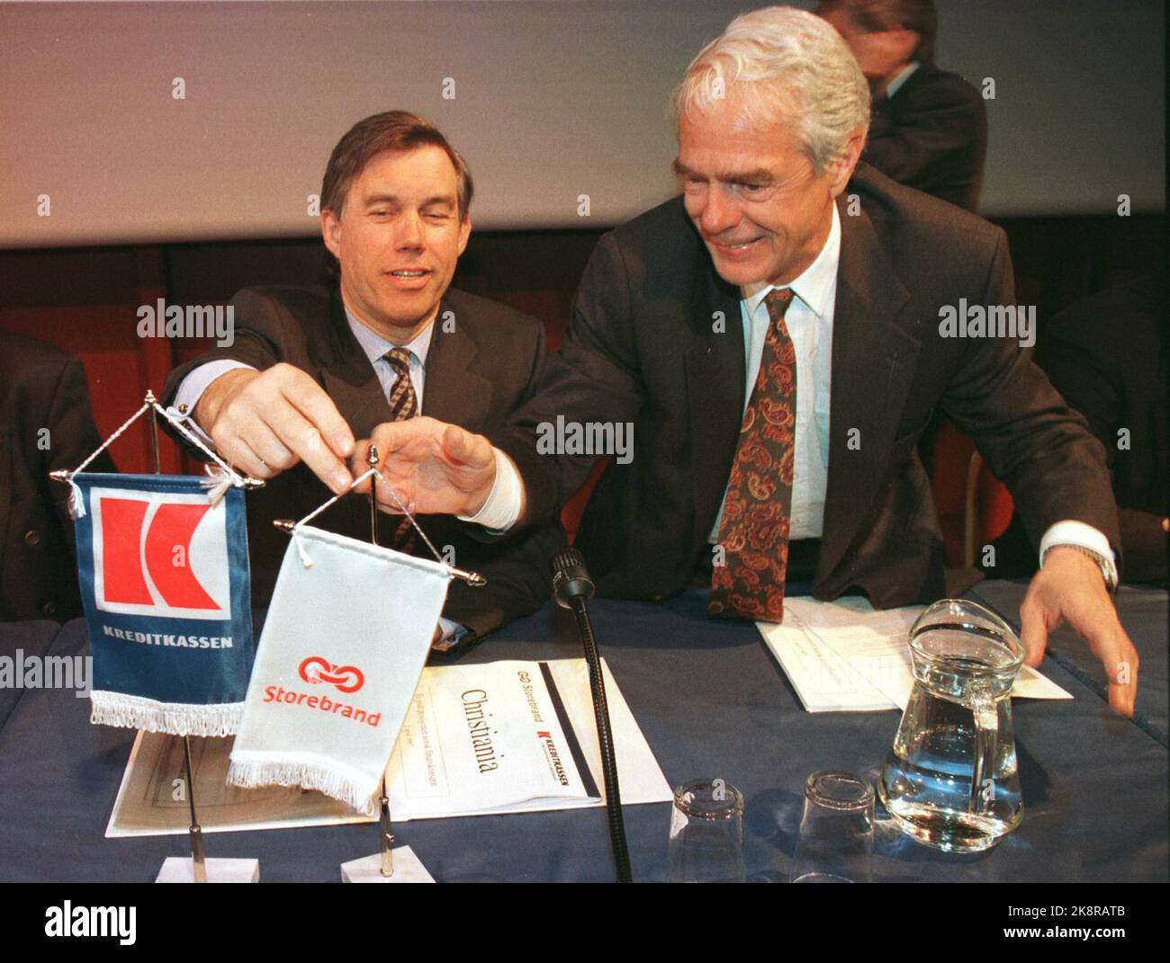 Oslo 19970402: CEO Åge Korsvold in Storebrand (t.v.) and CEO of Kreditkassen Borger A. Lenth help each other get a custom at the two companies' table pools before today's press conference on the merger between the two companies. The new company will be called Christiania. Photo: Erik Johansen / NTB Stock Photo
