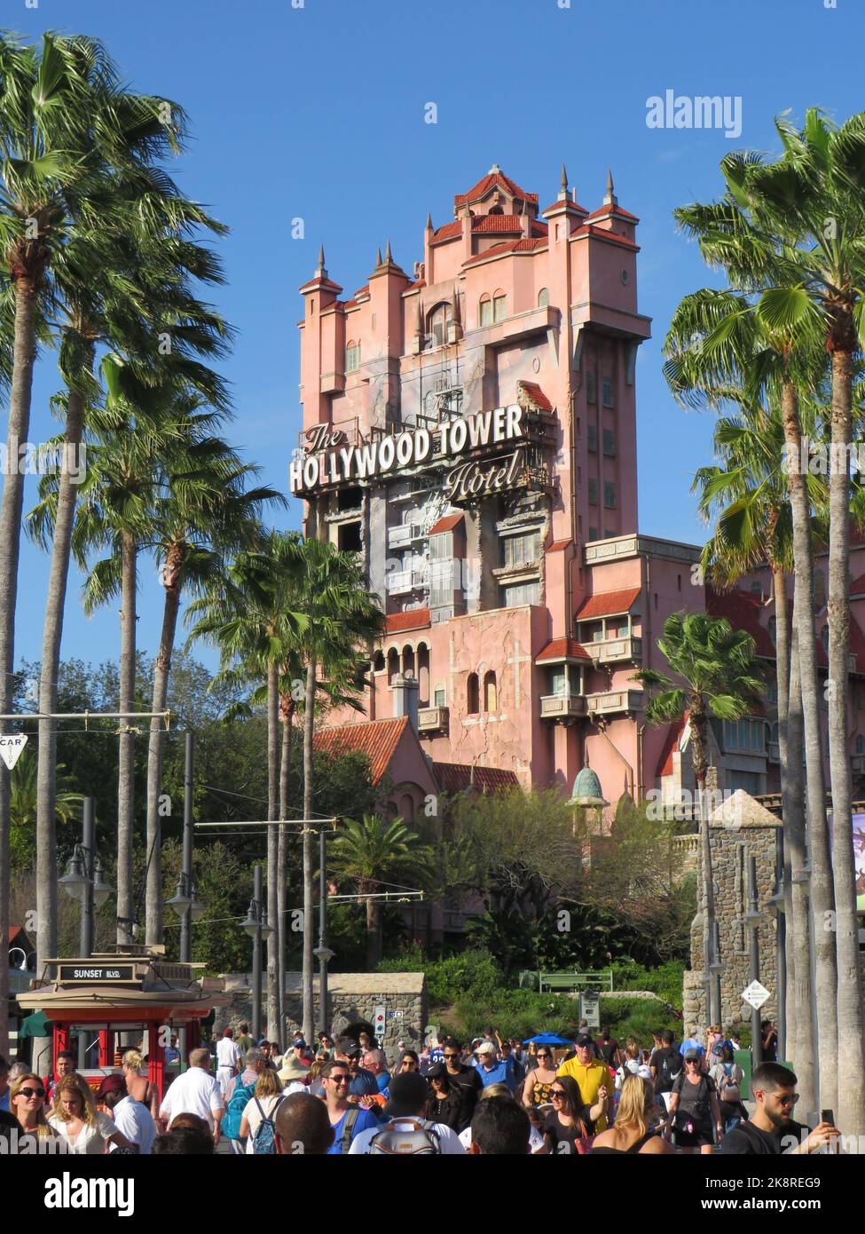 A vertical shot of the Hollywood Tower Hotel with people and palm trees around, Disney World, Orlando Stock Photo