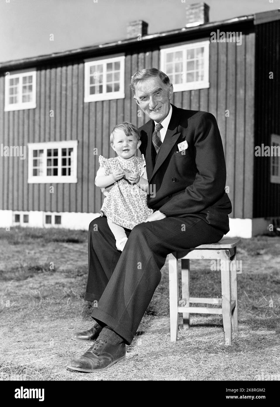 Røros 19490717 author Johan Falkberget with his grandson Ann Magritt on his lap, outside his home Ratvolden. Photo: NTB / NTB Stock Photo