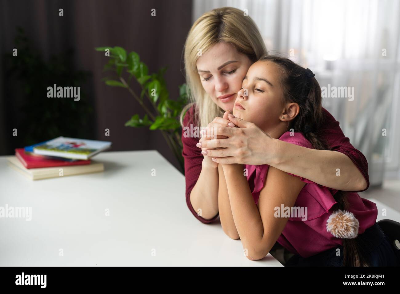 Mother teaching her daughter to praying. Stock Photo