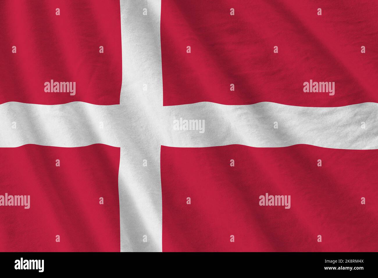 Denmark flag with big folds waving close up under the studio light indoors. The official symbols and colors in fabric banner Stock Photo
