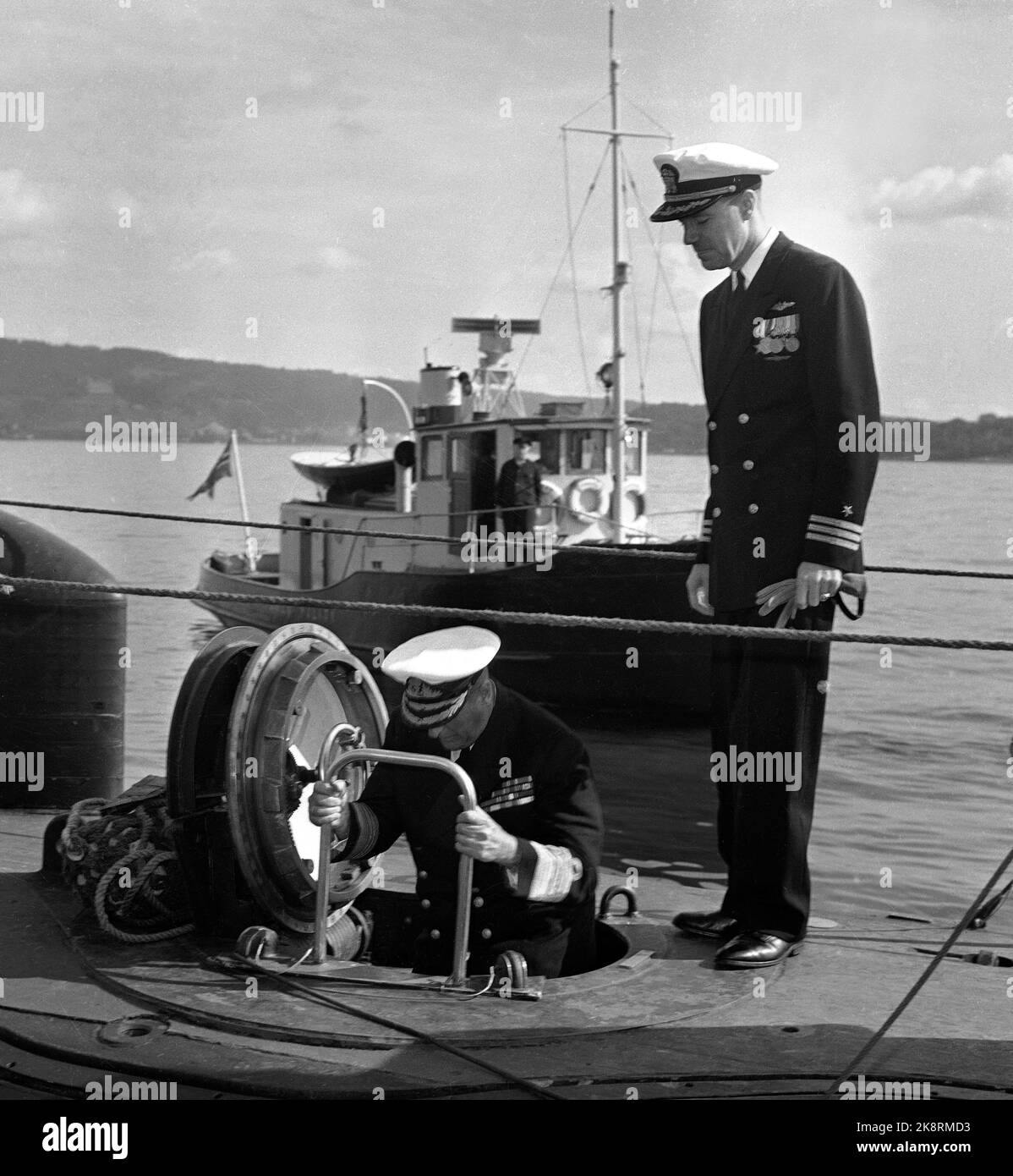 Oslo 19580826 The American submarine Skate, which has crossed the Arctic Ocean and the North Pole under the ice, visits Oslo. King Olav guests the boat at the harbor in Olso. Here the king is on his way down the nuclear-powered U-boat. Th. The commander's commander, Commander James Calvert. Photo: NTB / NTB Stock Photo