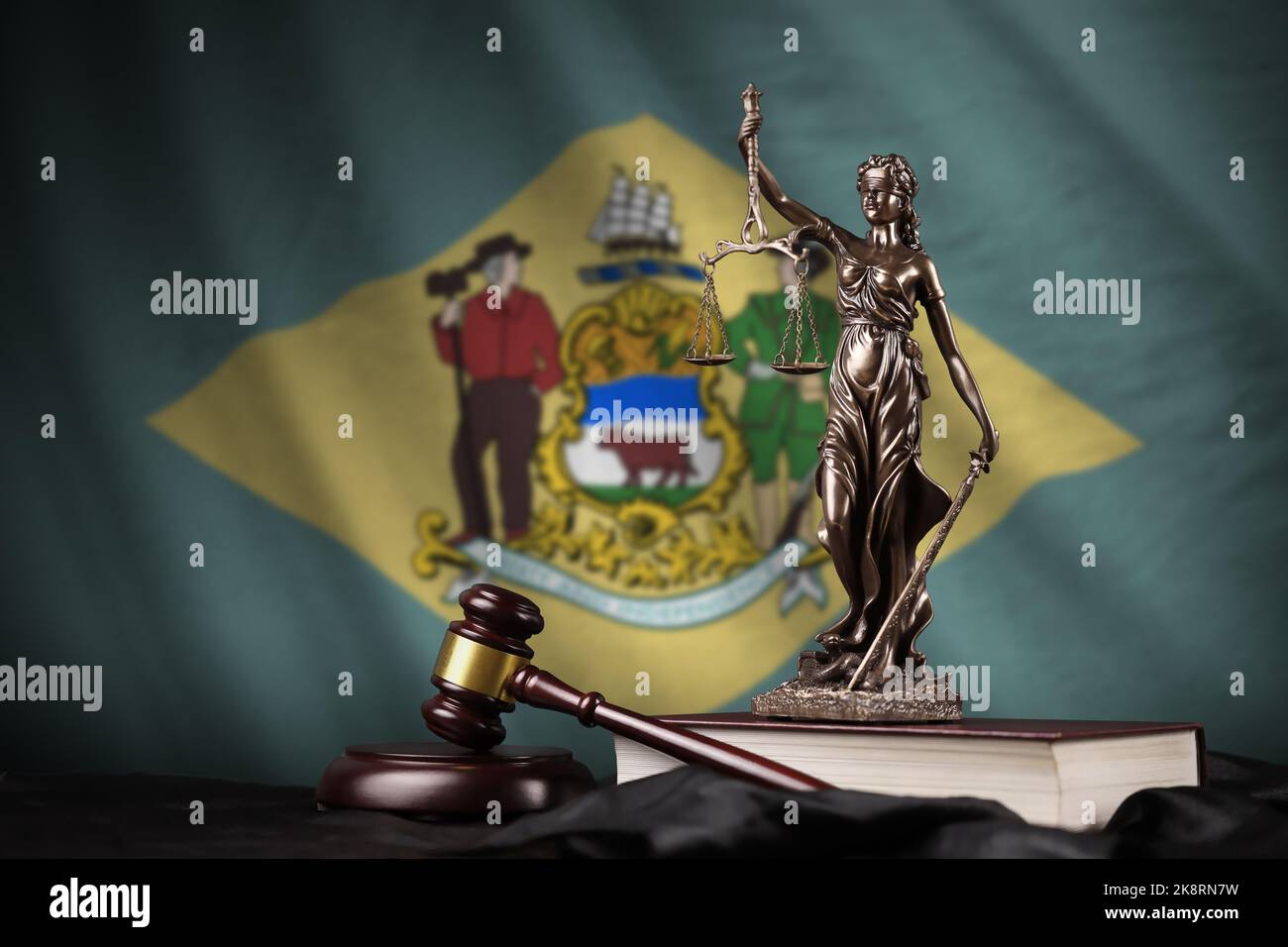 Delaware US state flag with statue of lady justice, constitution and judge hammer on black drapery. Concept of judgement and punishment Stock Photo
