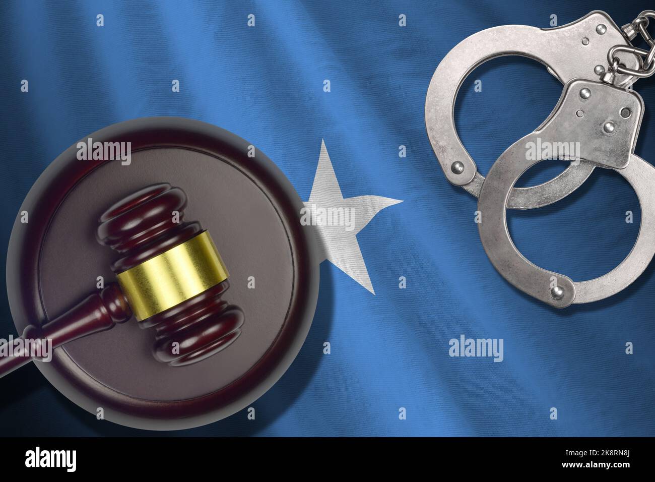 Somalia flag with judge mallet and handcuffs in dark room. Concept of criminal and punishment, background for guilty topics Stock Photo