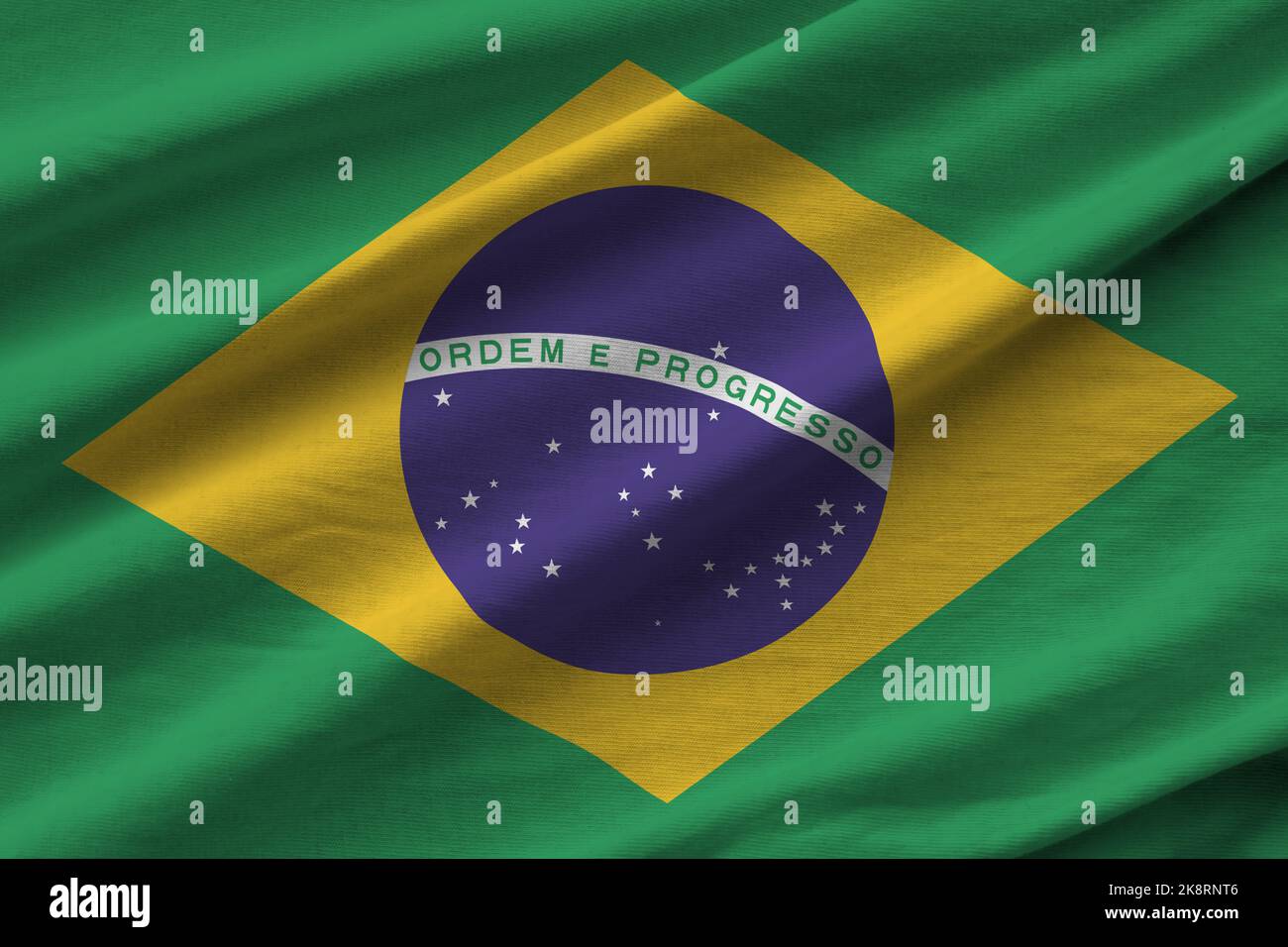 Brazil flag with big folds waving close up under the studio light indoors. The official symbols