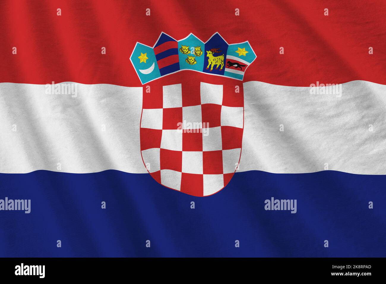 Croatia flag with big folds waving close up under the studio light indoors. The official symbols and colors in fabric banner Stock Photo