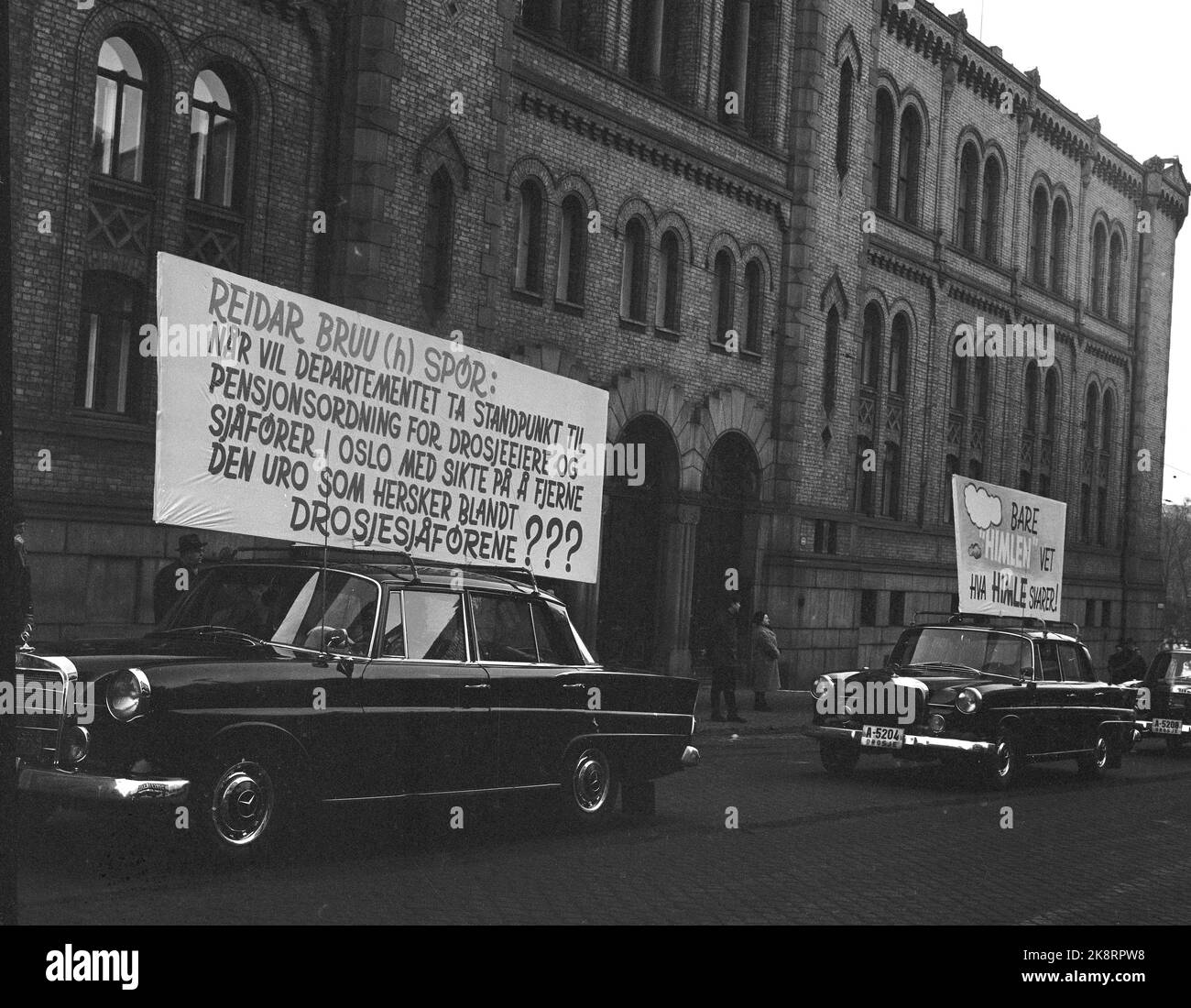 Oslo 19650110 Taxi drivers strike and demonstrate against poor working conditions and work agreements, including Lack of pension scheme. Paign with posters on the taxi cars up Karl Johans gate. Here they pass the Storting. Photo: NTB / NTB Stock Photo