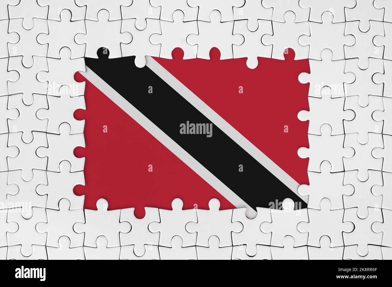 Trinidad and Tobago flag in frame of white puzzle pieces with missing central parts Stock Photo