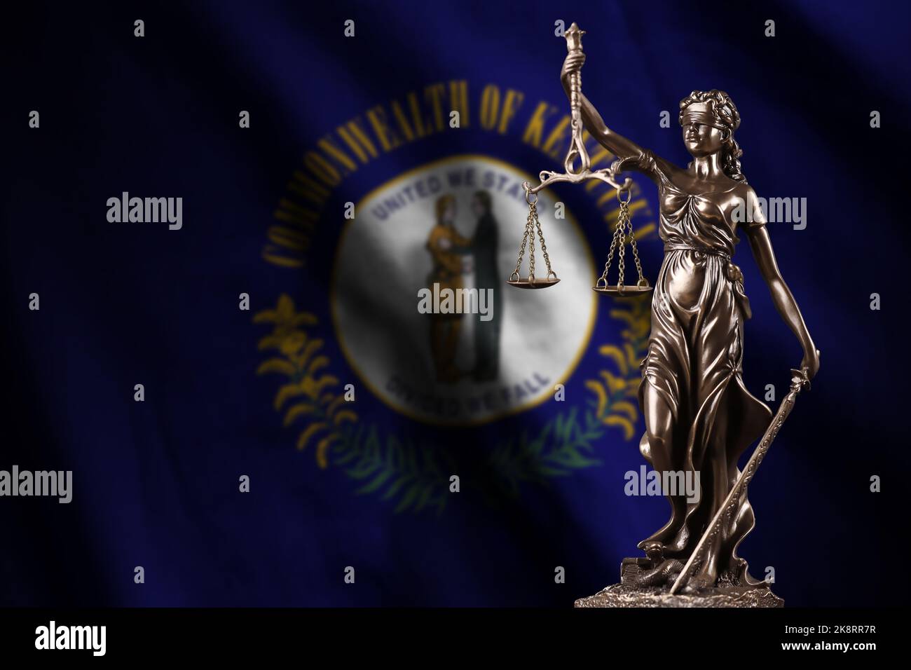 Kentucky US state flag with statue of lady justice and judicial scales in dark room. Concept of judgement and punishment, background for jury topics Stock Photo