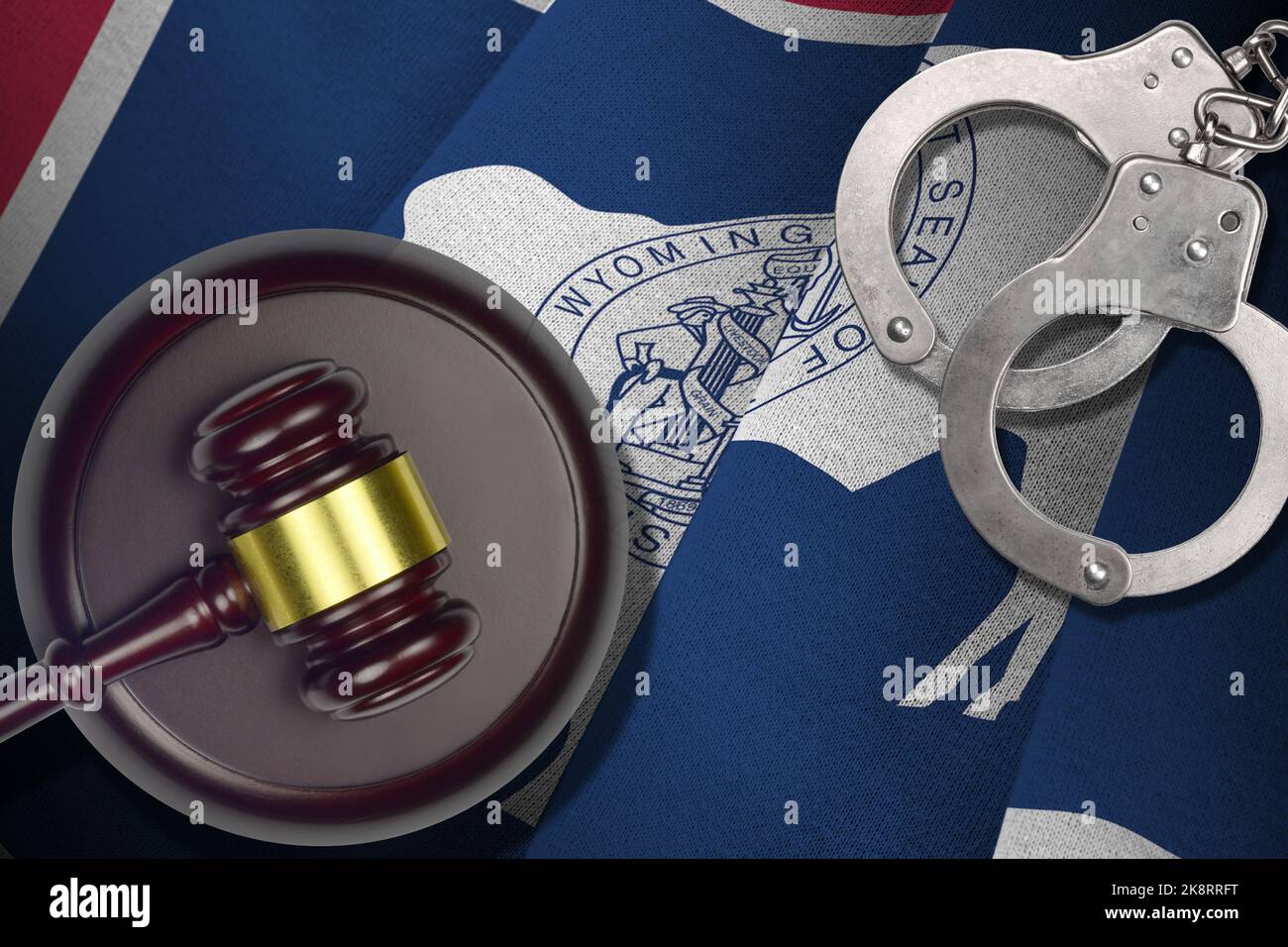 Wyoming US state flag with judge mallet and handcuffs in dark room. Concept of criminal and punishment, background for guilty topics Stock Photo