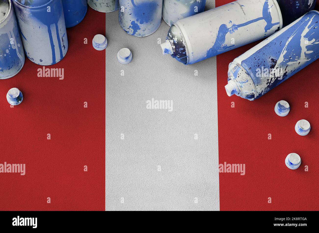 Peru flag and few used aerosol spray cans for graffiti painting. Street