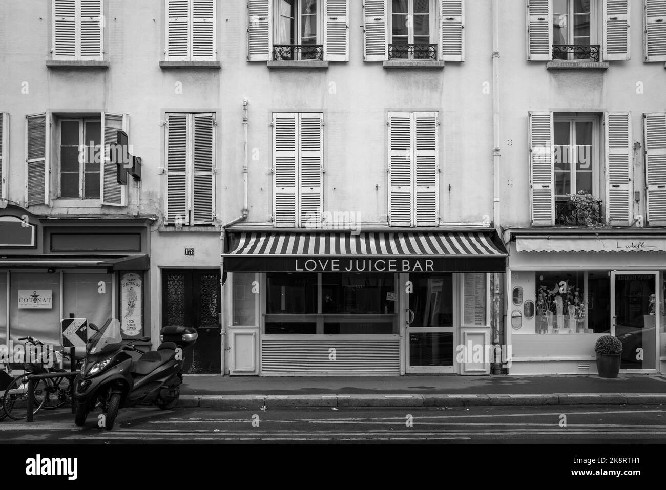 A grayscale of Love Juice Bar in Paris with a motorcycle in the foreground, France Stock Photo