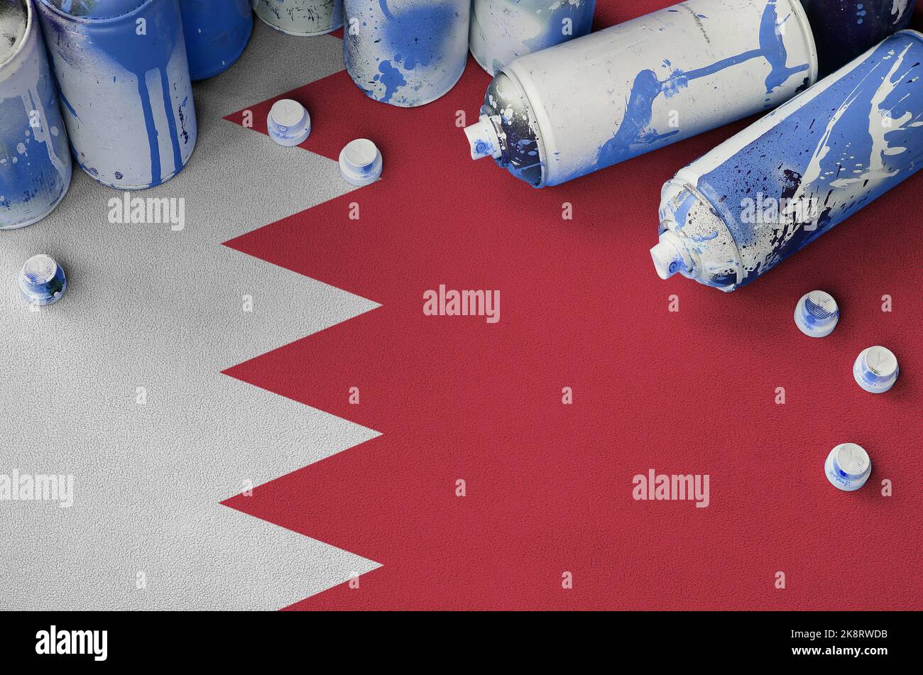 Bahrain flag and few used aerosol spray cans for graffiti painting