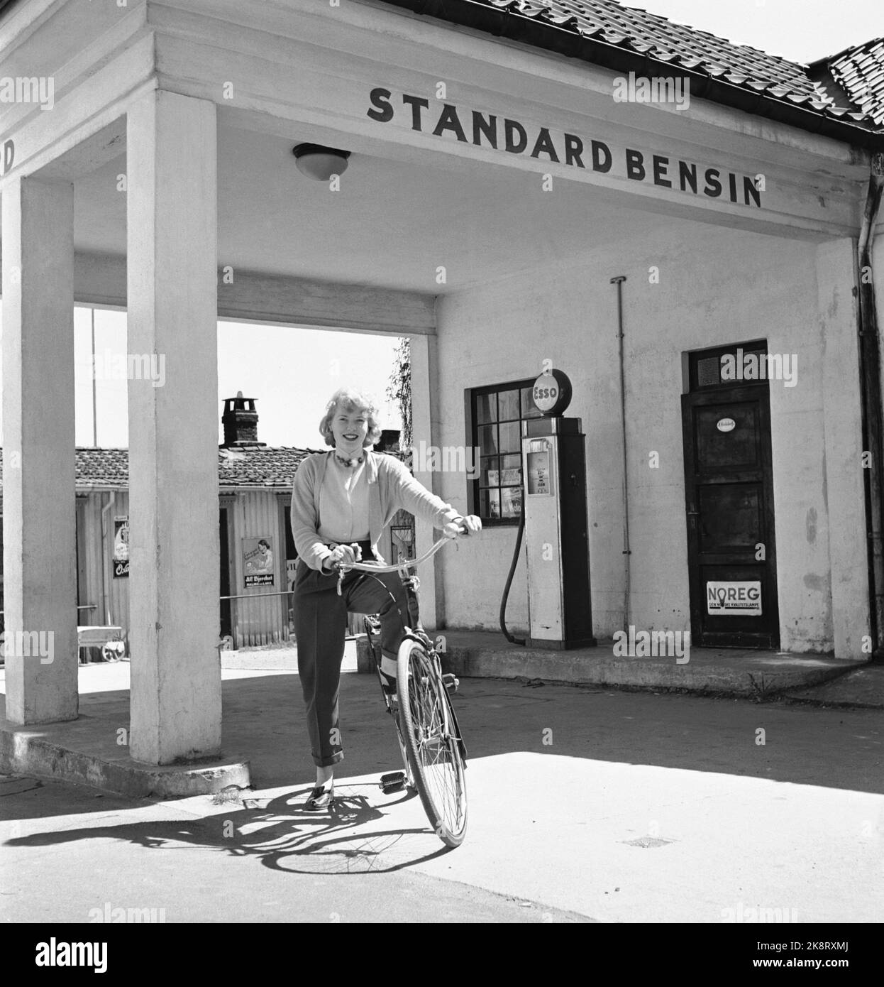Kragerø 195406 - summer pictures from Kragerø. Young woman with bicycle outside the gas station standard gasoline. Photo: Current / NTB Stock Photo