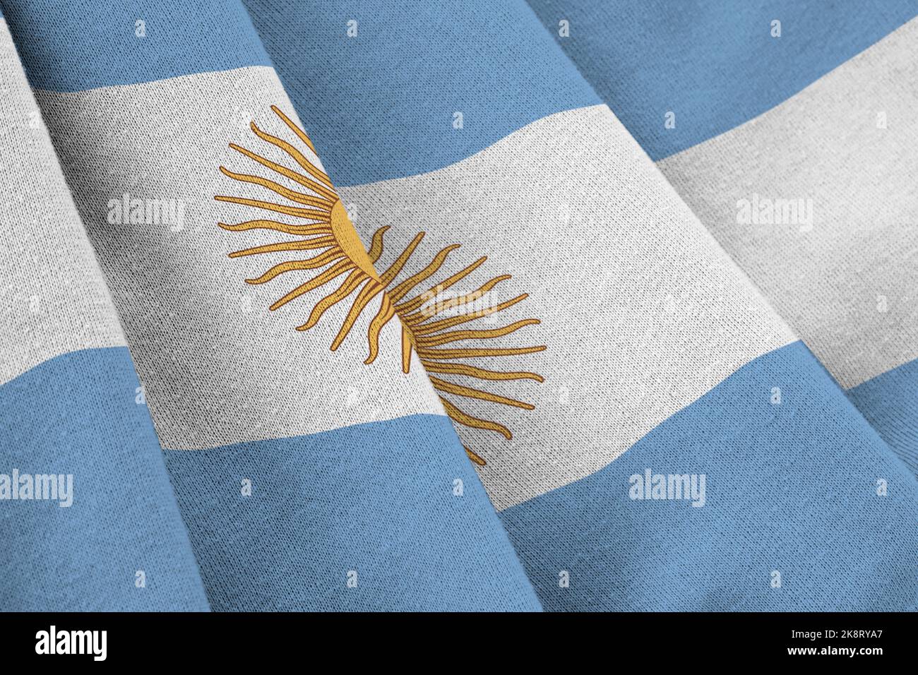 Argentina flag with big folds waving close up under the studio light indoors. The official symbols and colors in fabric banner Stock Photo