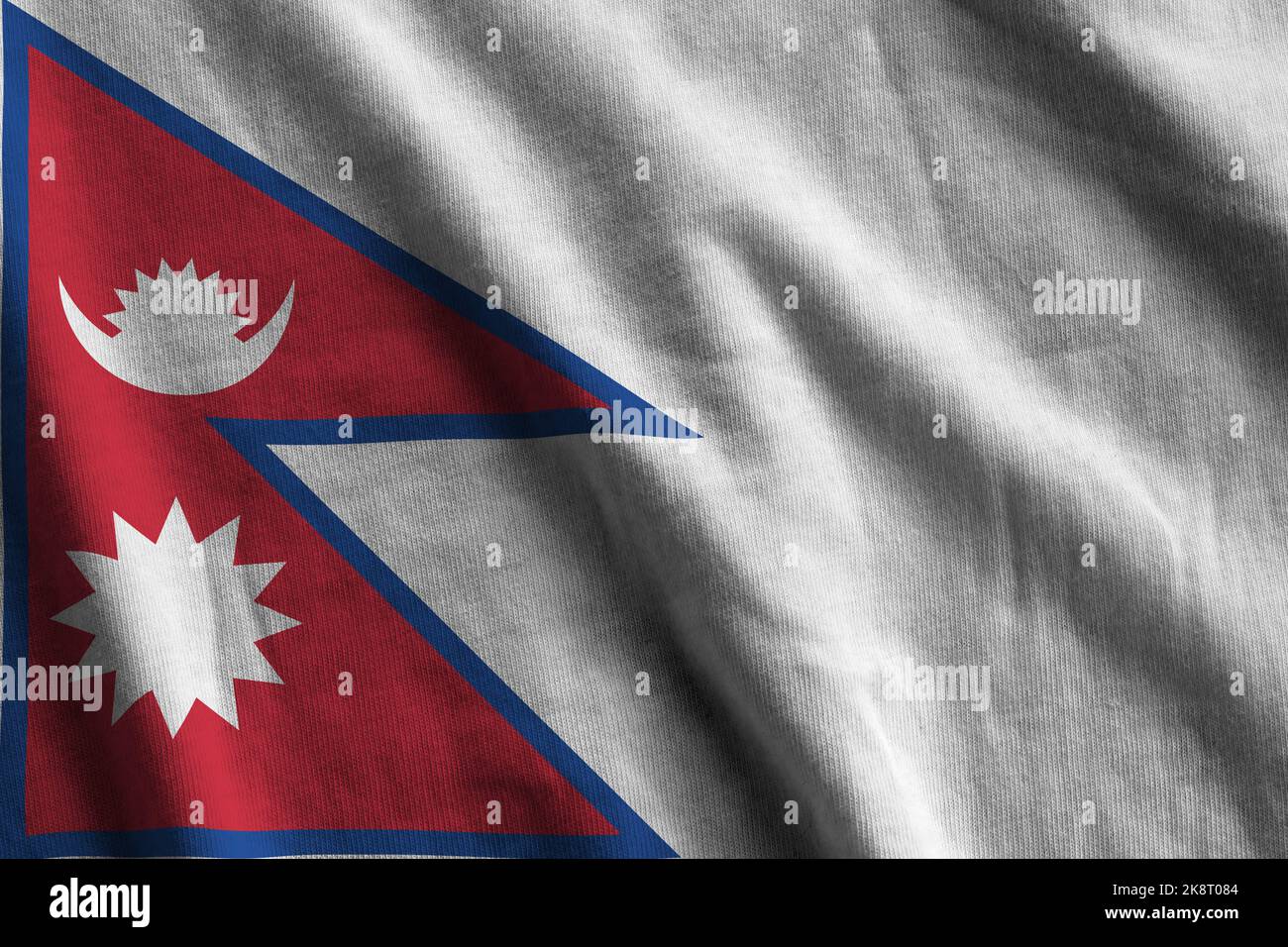 Nepal flag with big folds waving close up under the studio light