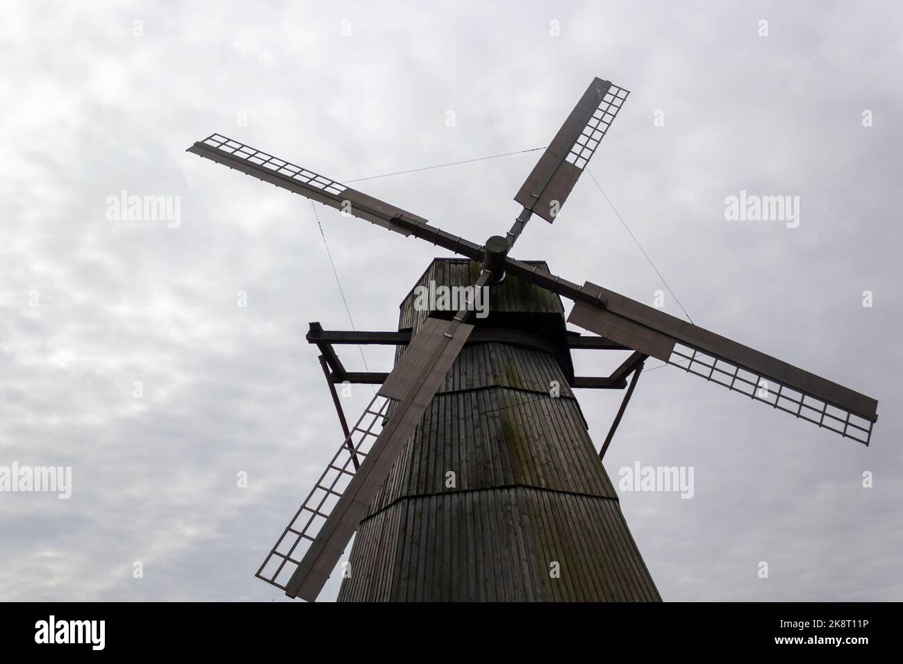 Detail of the wooden blades of an old windmill against a gray sky. Stock Photo