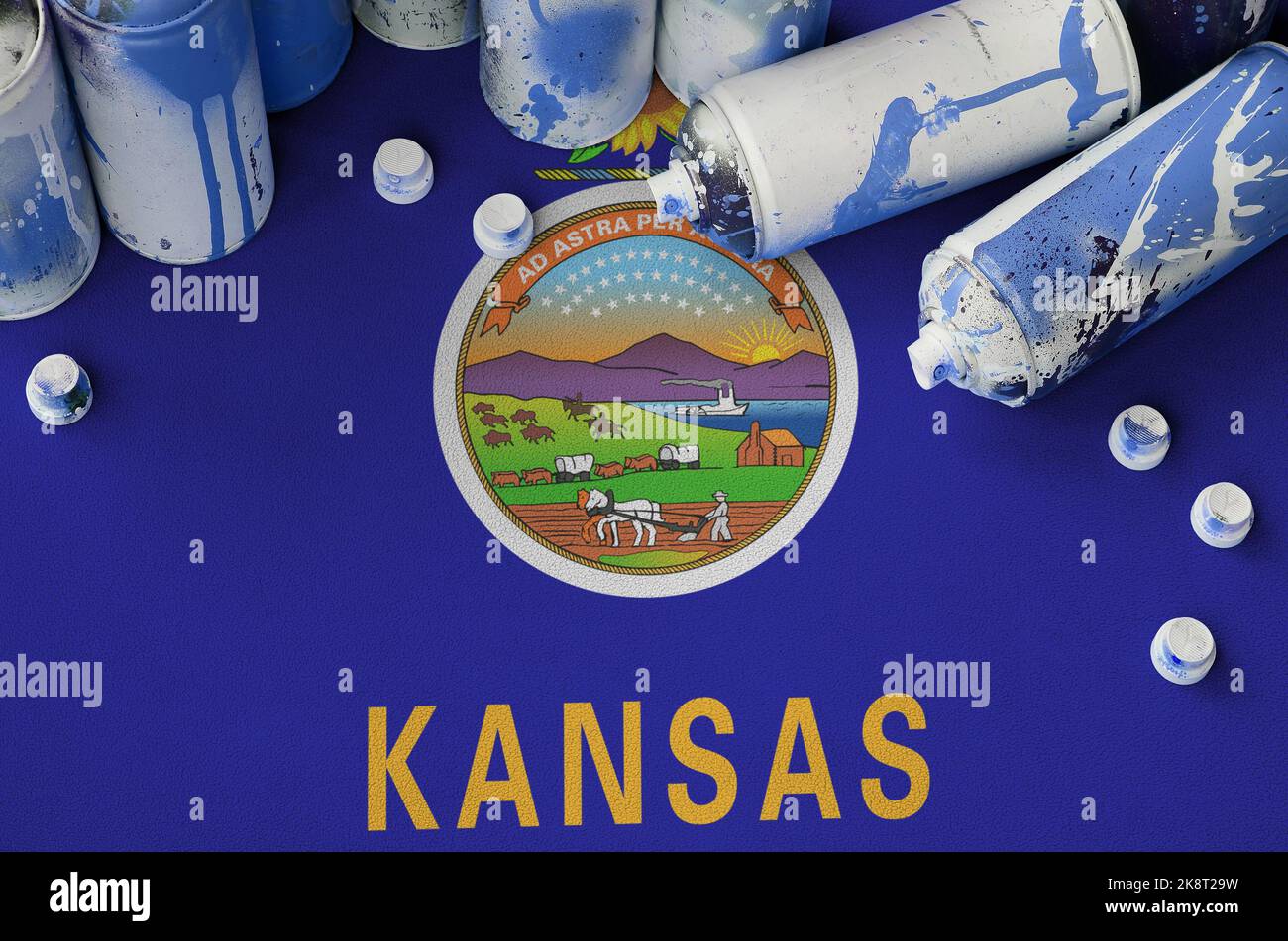 Kansas US state flag and few used aerosol spray cans for graffiti