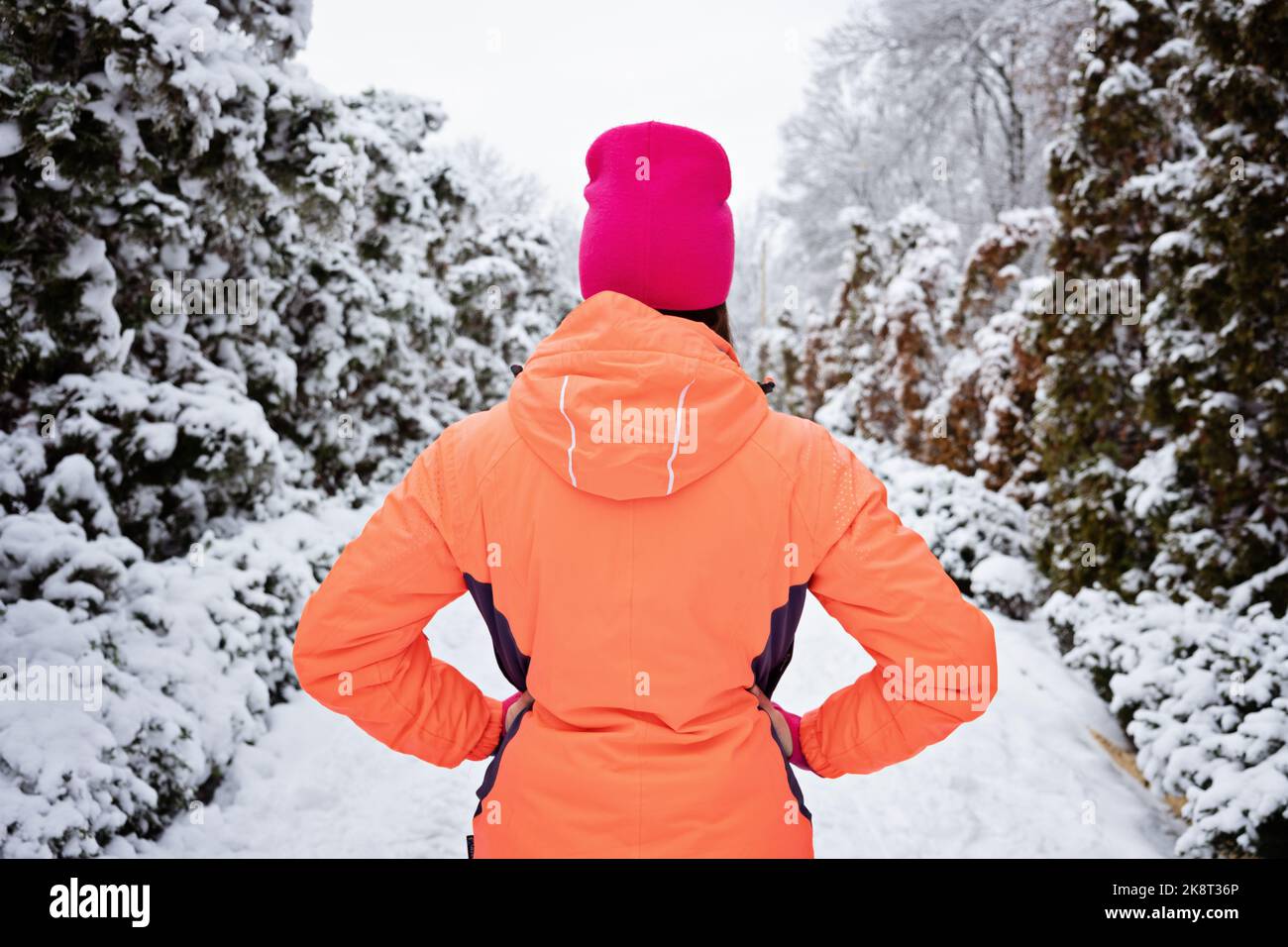 Winter workout, exercising in cold weather. Winter fitness, Safety tips for exercising outdoors. Sporty woman in sportswear standing in winter snowy Stock Photo
