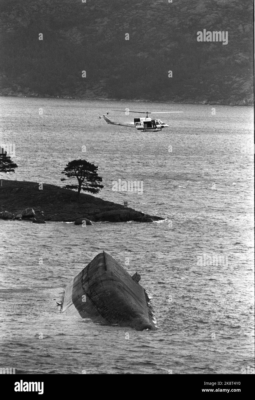 Stavanger 19851105: The cement vessel Concem crashed during the work on Gullfaks B Platform in the Gandsfjord, and 10 people perished. Here the overturned cement bargain. Helicopter is looking for the missing / dead. Photo: Jens O. Kvale / NTB / NTB Stock Photo