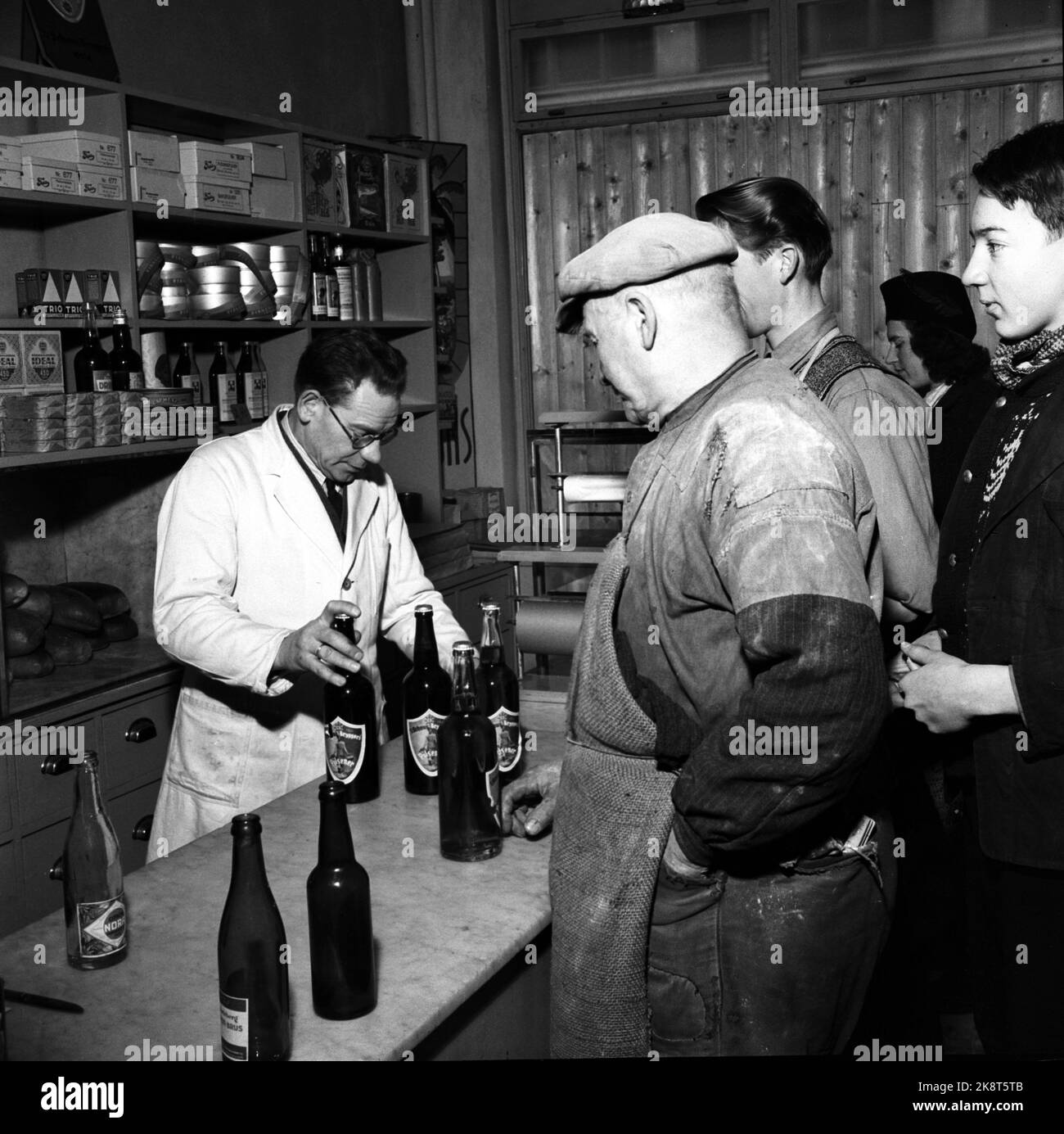Oslo 19460121. Pilsen has returned to the shops. First day after the war with the sale of beer over the counter. Customers are in line in front of the counter inside a store. Stock Photo NTB / NTB Stock Photo