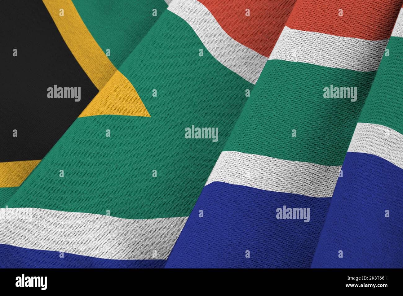 South Africa flag with big folds waving close up under the studio light indoors. The official symbols and colors in fabric banner Stock Photo
