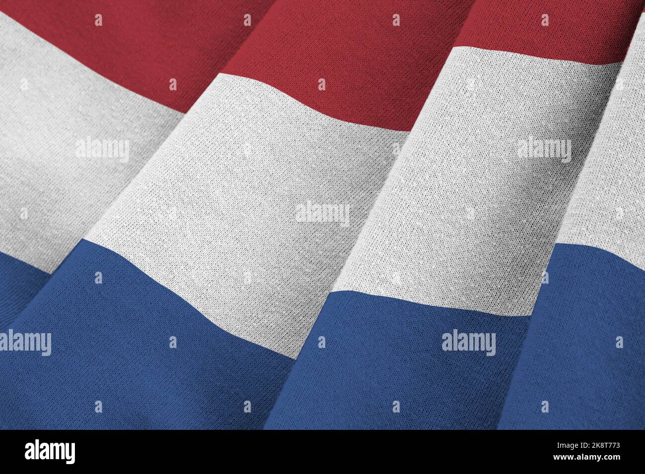 Netherlands flag with big folds waving close up under the studio light indoors. The official symbols and colors in fabric banner Stock Photo