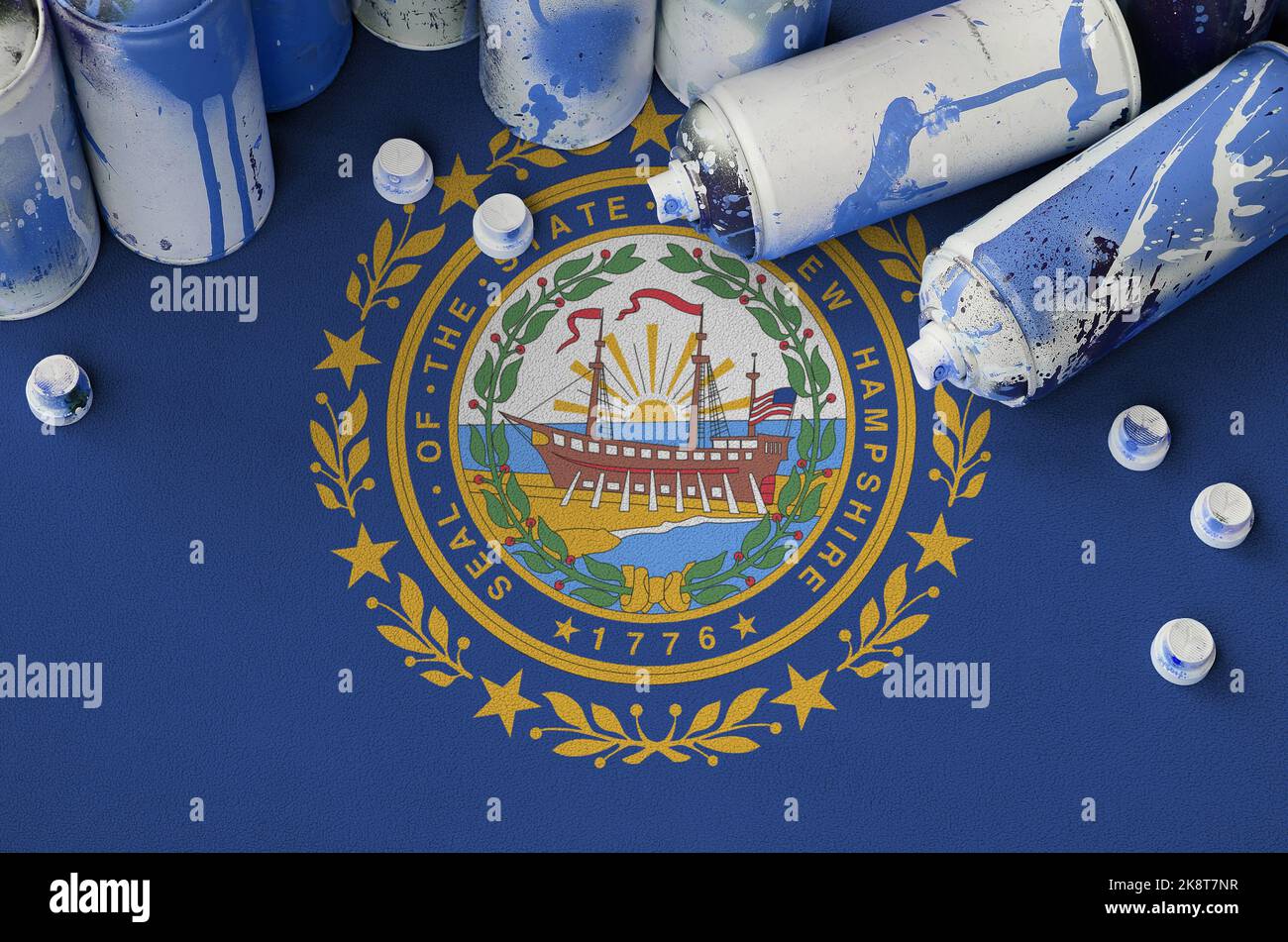 New Hampshire US state flag and few used aerosol spray cans for